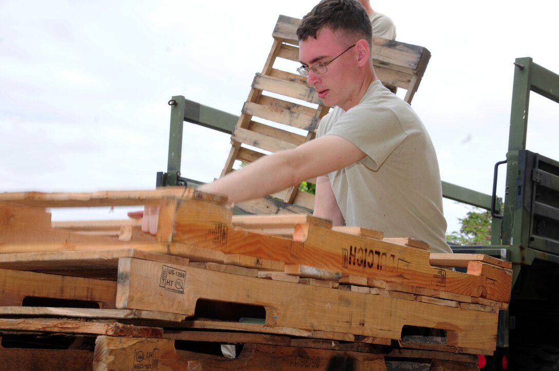 Senior Airman Nicholas Walters, 36th Maintenance Squadron aircraft electrical and environmental systems specialist, stacks pallets during a volunteer event at Andersen Middle School here Feb. 7, 2013. Fifteen Airmen from Team Andersen volunteered to box and palletize more than 400 desks at AMS and send them to the Defense Reutilization and Marketing Office on Naval Base Guam. (U.S. Air Force photo by Senior Airman Robert Hicks/Released) 