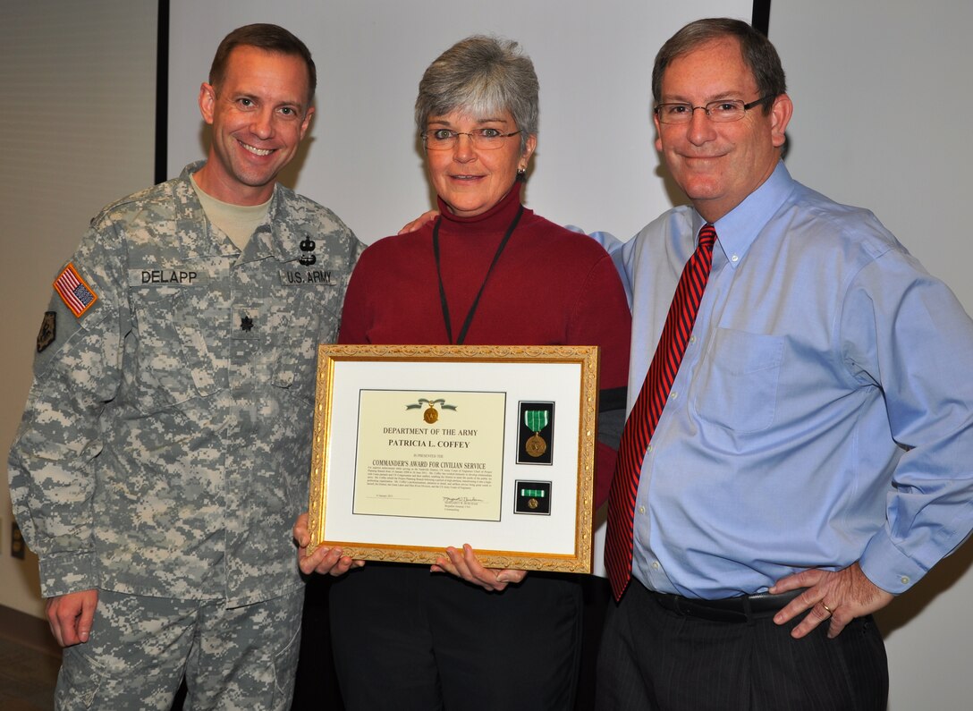 Patty Coffey, center, presently assistant chief, Nashville District Operations Division, holds the Great Lakes and Ohio River Division Commander’s Award for Civilian Service she received Feb. 11, 2013 for her previous service as chief, Nashville District Planning Branch. Lt. Col. James A. DeLapp, left, Nashville District commander, and Mike Wilson, right, deputy district engineer for programs and project management, made the presentation of behalf of Brig. Gen. Margaret W. Burcham, division commander.