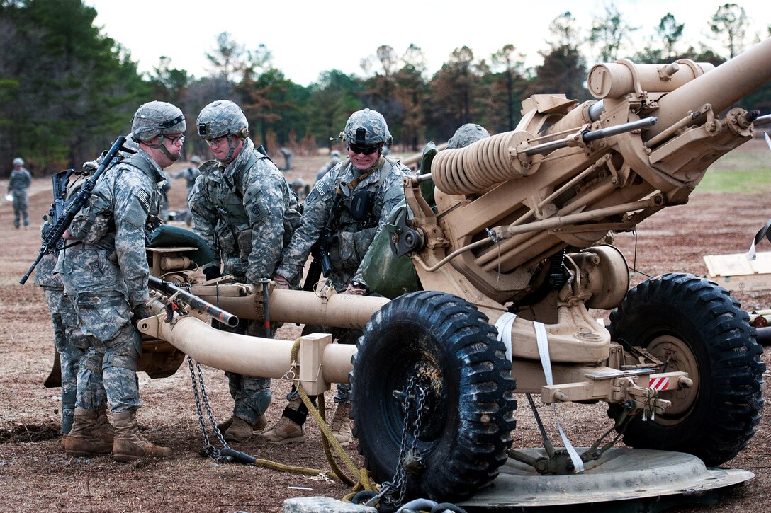 Paratroopers pack up their M119A2 howitzer for transport by UH-60 Black ...