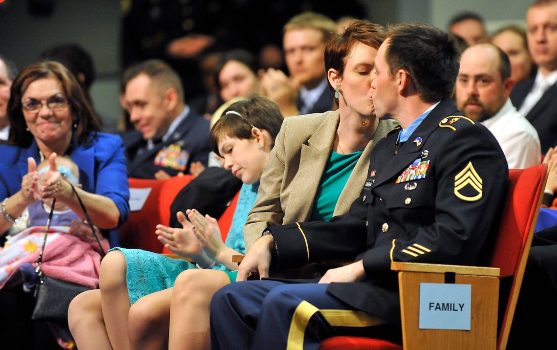 Former Army Staff Sgt. Clinton L. Romesha receives a kiss from his wife, Tamara, at the Pentagon, Feb. 12, 2013, during a ceremony to honor him for receiving the Metal of Honor. The kiss followed a comment that it also was their anniversary. 