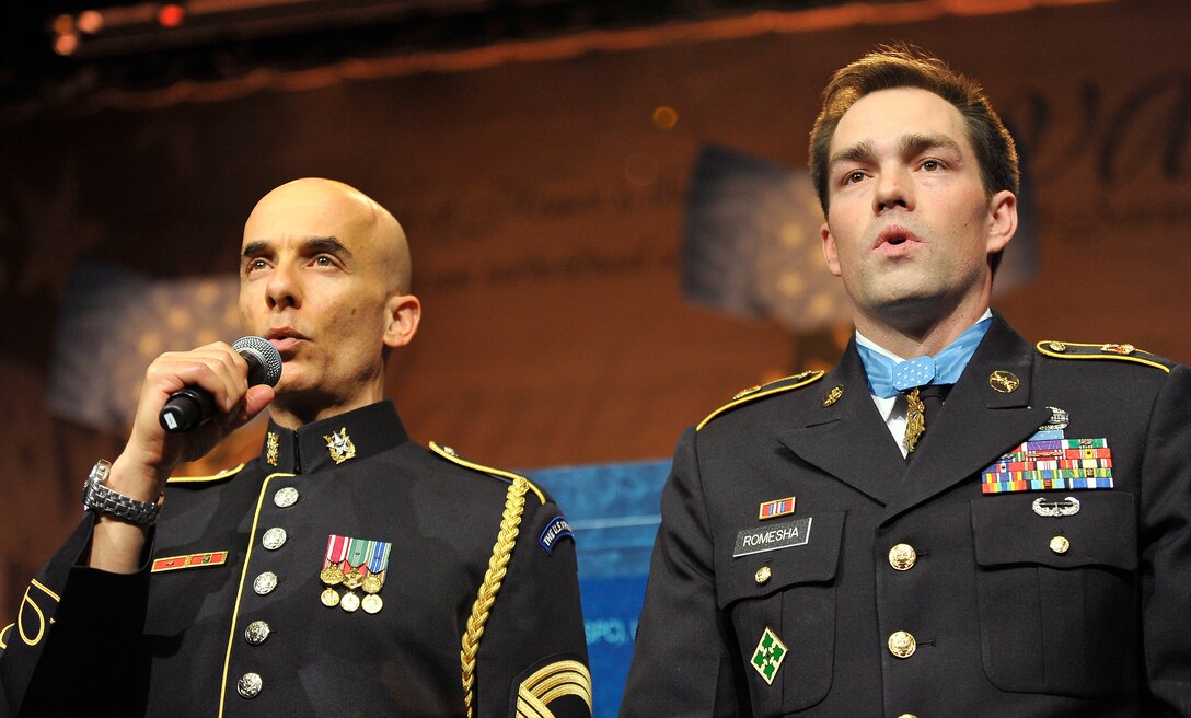 Former Army Staff Sgt. Clinton L. Romesha, right, a Medal of Honor recipient, sings the Army song on stage after a ceremony honoring him at the Pentagon, Feb. 12, 2013.