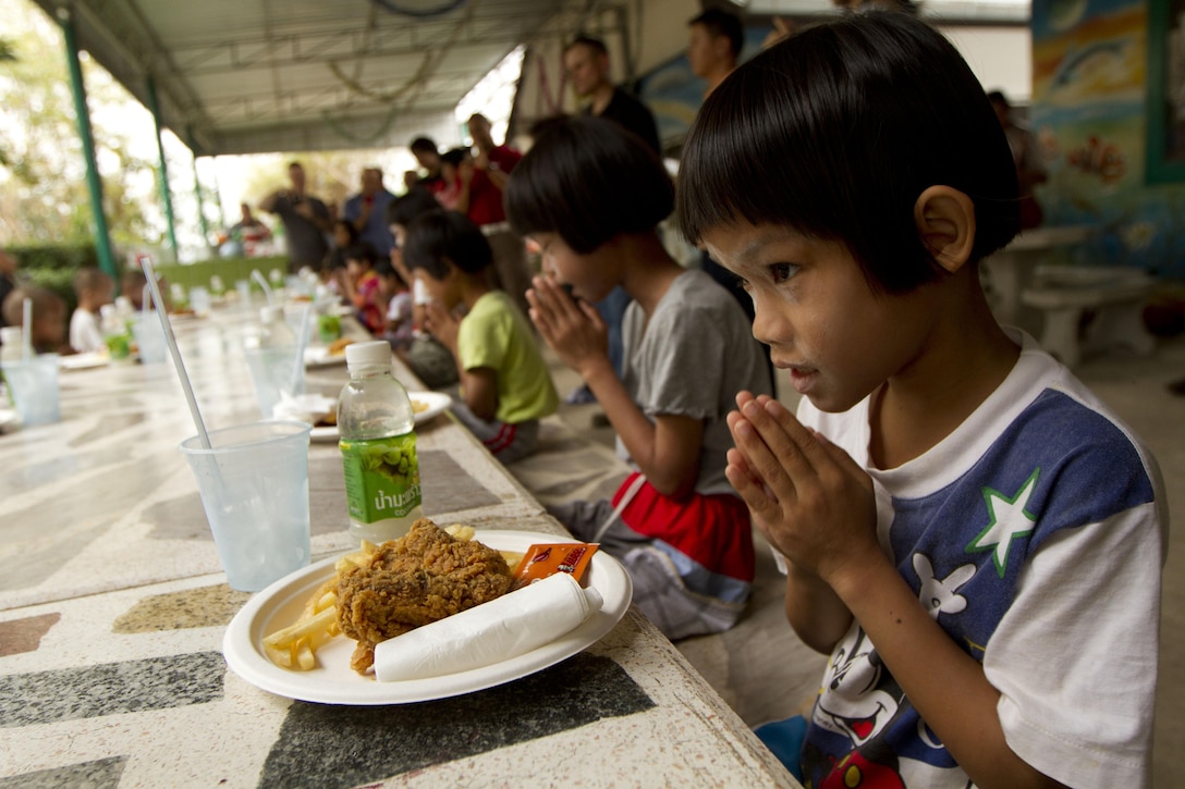 Palw, a child at the Thailand Children's Home in Nakhon Ratchasima, Kingdom of Thailand, prays before eating her meal Feb. 9. The meal was provided by U.S. Marines and sailors with 1st Marine Aircraft Wing before the start of exercise Cobra Gold 2013. The visit was part of a community relations event to help meet the basic needs of our Thai friends and partners. CG 13, in its 32nd iteration, is a multinational exercise that promotes regional prosperity, security and cooperation among partner militaries. 1st MAW is part of III Marine Expeditionary Force.