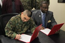 Lt. Col. Vincent J. Yasaki, commanding officer of the Center for Naval Aviation Technical Training, and Dr. Daryl Minus, executive vice president for learning and student success at Craven Community College sign an agreement to help CNATT Marines acquire degrees, Jan. 28. The participants in the program will receive up to four classes worth of credits for having done their military training.
