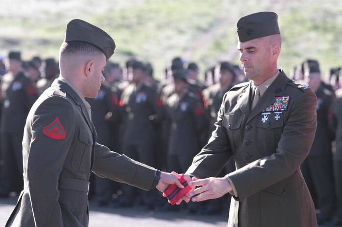 MARINE CORPS BASE CAMP PENDLETON, Calif. – A Marine presents a streamer to Col. Peter B. Baumgarten, the 1st Marine Regiment commanding officer, during a battle color rededication ceremony here, Feb. 11, 2013. Baumgarten, a native of El Paso, Texas, and a graduate of the U.S. Naval Academy, directed his Marines and sailors to use the ceremony as a time to reflect on their unit’s history, a precedent set by the commanding general of the 1st Marine Division, Maj. Gen. Ronald Bailey.(U.S. Marine Corps photo by Sgt. Jacob H. Harrer)