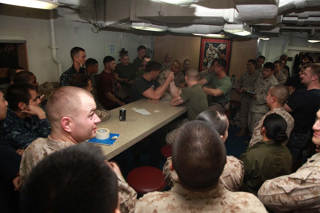 Marines and sailors with the 15th Marine Expeditionary Unit and Peleliu Amphibious Ready Group participated in an arm wrestling competition held on the troop mess decks of the USS Peleliu, Feb. 6. The rules for the arm wrestling tournament involved one untimed round per opponent. The goal of each match was to pull down on the other person's arm until their wrist hit the table. The 15th MEU is deployed as part of the Peleliu ARG as a U.S. Central Command theater reserve force, providing support for maritime security operations and theater security cooperation efforts in the U.S. 5th Fleet area of responsibility. (U.S. Marine Corps photo by Cpl. John Robbart III/Released)