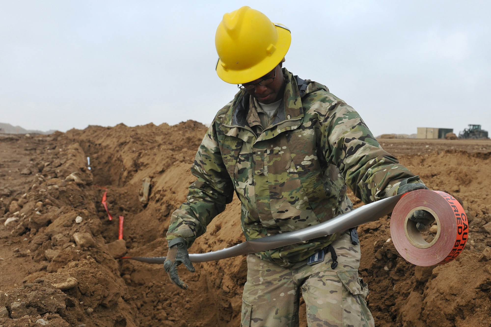 Senior Airman Shawna Fowler, 272nd Engineering and Installation Squadron journeyman, lays underground cable warning tape in a recently backfilled trench at Camp Pratt, Afghanistan, Jan. 31, 2013. Fowler, a Houston, Texas, native, is part of a team tasked to lay the entire fiber optic cable infrastructure connecting Camp Marmal to Camp John Pratt.  (U.S. Air Force photo/Senior Airman Chris Willis)