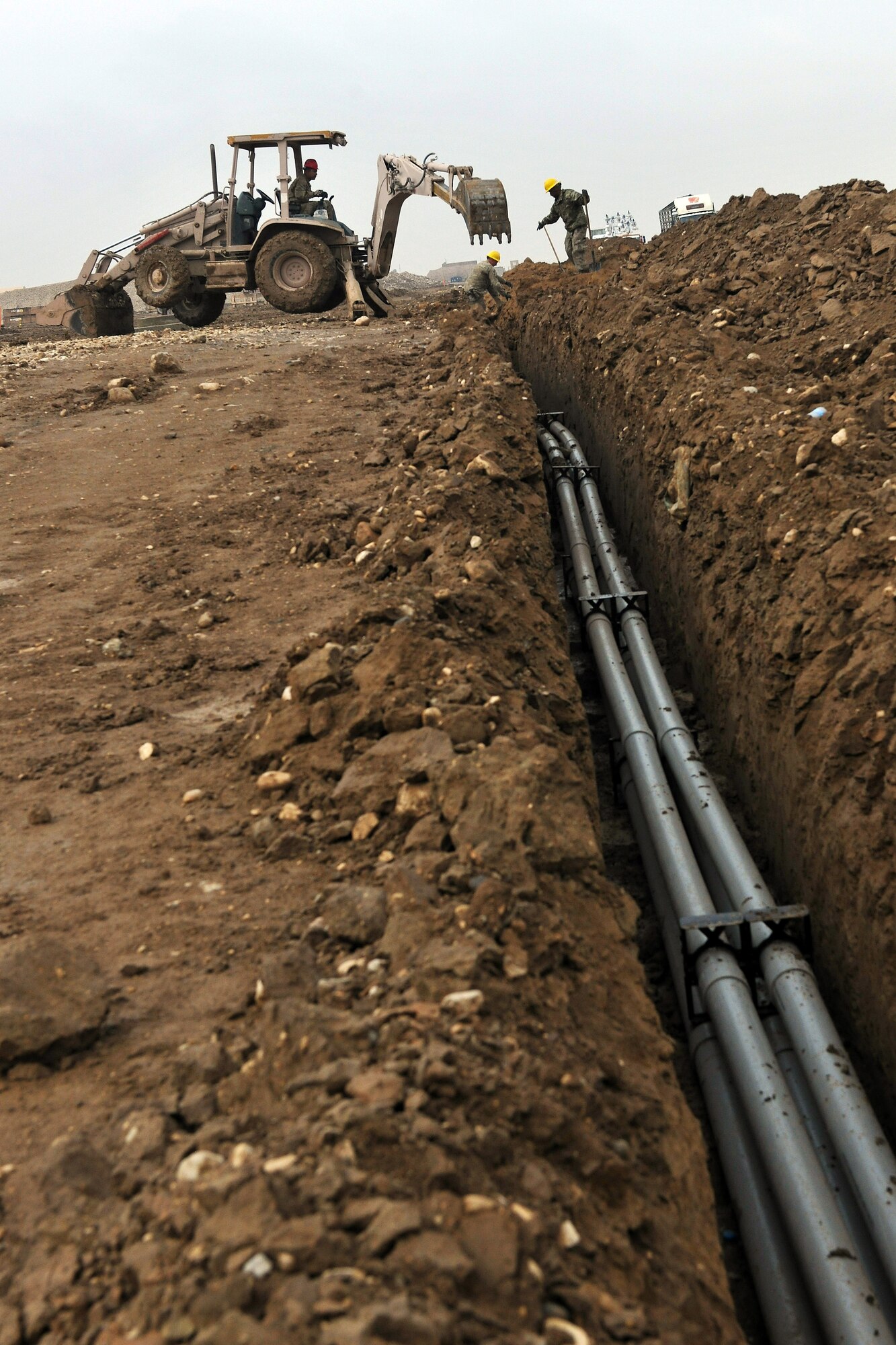 Members of the 272nd Engineering and Installation Squadron dig trenches for fiber optic cables through Camp John Pratt, Afghanistan, Jan. 31, 2013.  The 272nd EIS is tasked with constructing the communications infrastructure used by thousands of servicemembers and military contractors at the camps located near the city of Mazar-e-Sharif. (U.S. Air Force photo/Senior Airman Chris Willis)