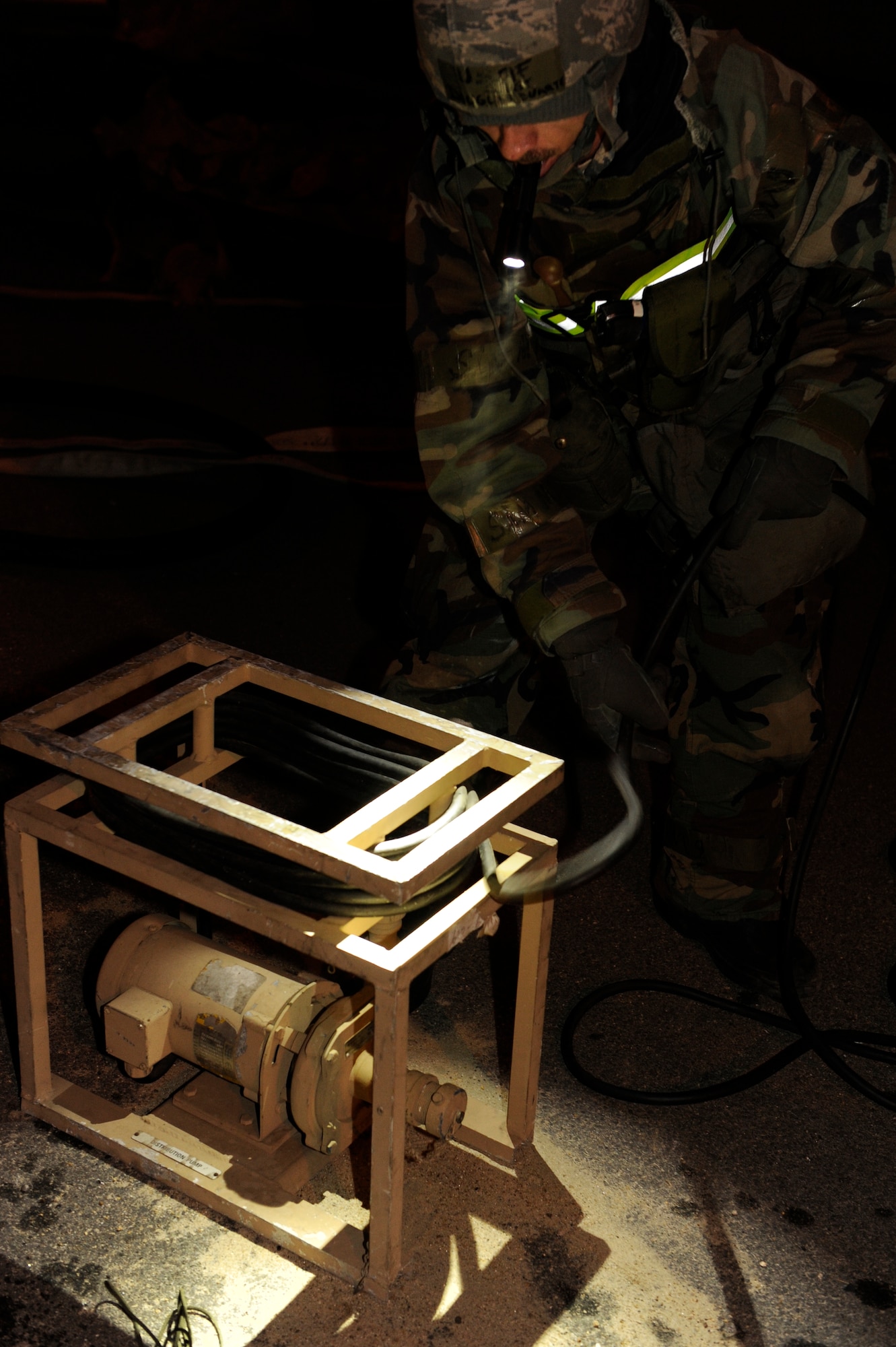 Staff Sgt. Douglas Duarte, 8th Civil Engineer Squadron, unwraps cables from a pump during exercise Beverly Bulldog 13-2 at Kunsan Air Base, Republic of Korea, Feb. 13, 2013. Duarte was turning on a reverse-osmosis, water-purification system after a simulated water shortage forced the base to use a different source. (U.S. Air Force photo by Senior Airman Marcus Morris/Released)
