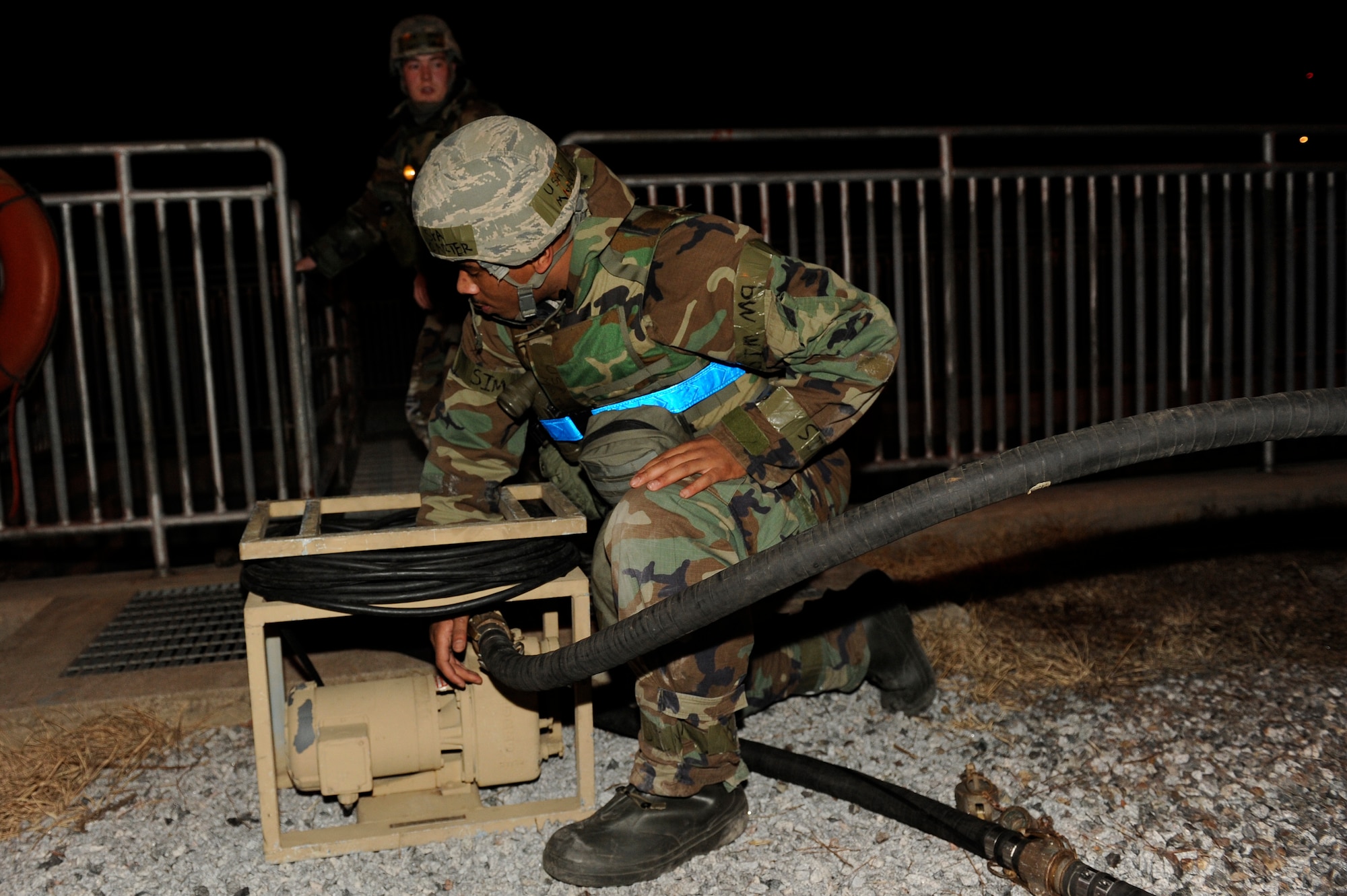 Senior Airman Marvin Carter, 8th Civil Engineer Squadron, connects a hose to a pump during exercise Beverly Bulldog 13-2 at Kunsan Air Base, Republic of Korea, Feb. 13, 2013. The Airmen were turning on a reverse-osmosis, water-purification system after a simulated water shortage forced the base to use a different source. (U.S. Air Force photo by Senior Airman Marcus Morris/Released)