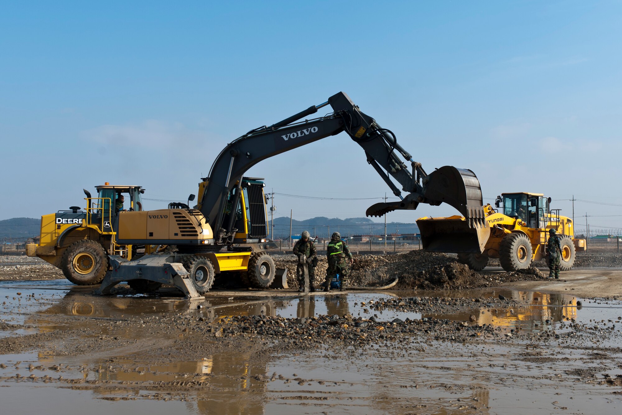 KUNSAN AIR BASE, Republic of Korea -- Airmen of the 8th Civil Engineer Squadron remove water from a simulated bombed runway during Exercise Beverly Bulldog 13-2 at Kunsan Air Base, Republic of Korea Feb. 13, 2013. The team of 40 members filled the crater and placed a fiberglass mat over the top, making the runway active again.  (U.S. Air Force photo by Tech. Sgt. Michael Schocker)