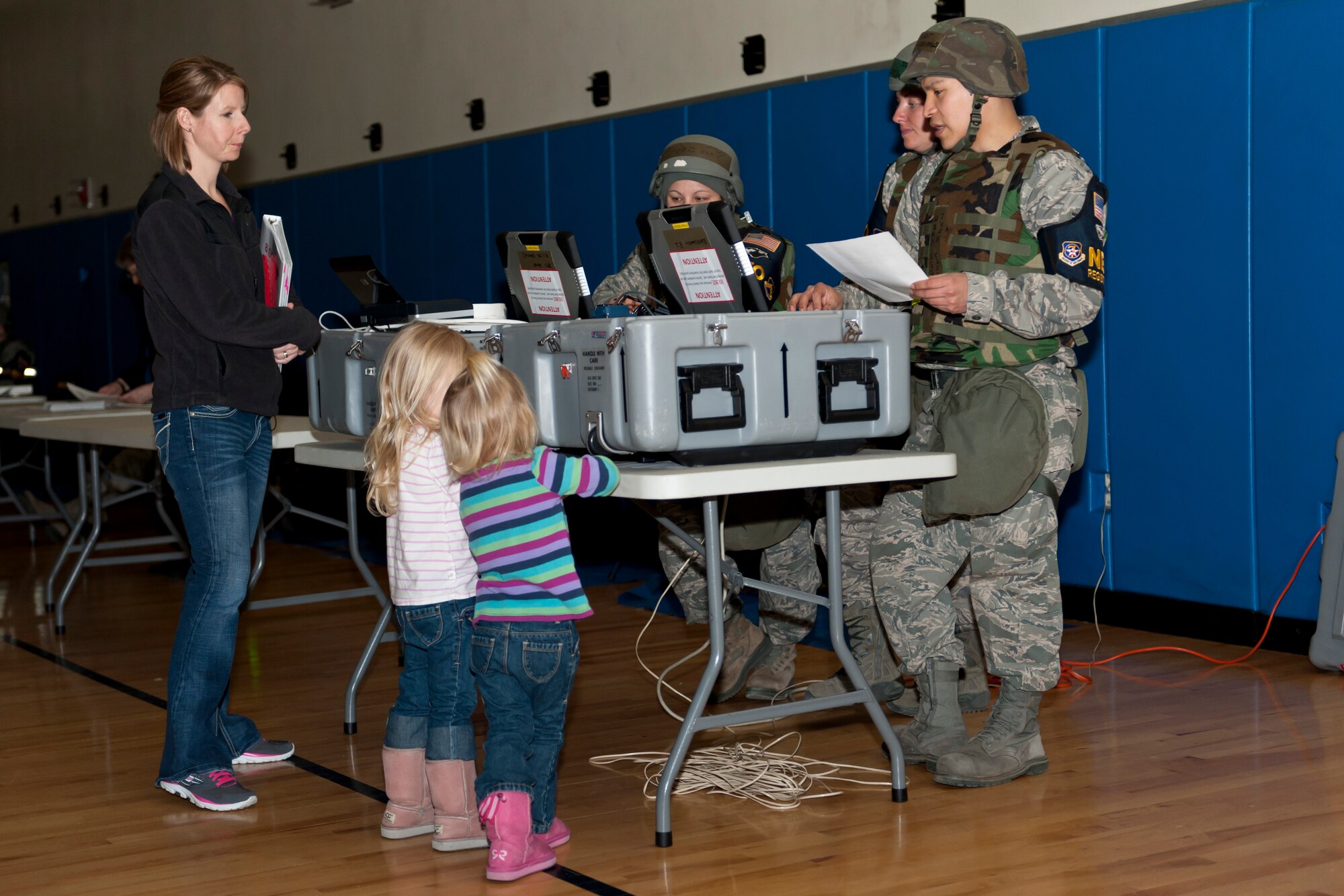 KUNSAN AIR BASE, Republic of Korea -- The Norwood family goes through the processing line during the Noncombatant Evacuation Operation exercise during exercise Beverly Bulldog 13-2 at Kunsan Air Base, Republic of Korea Feb. 12, 2013. Similar to a deployment line, the NEO line has information from many agencies around base to help members transition off the peninsula if necessary.    (U.S. Air Force photo by Tech. Sgt. Michael Schocker)