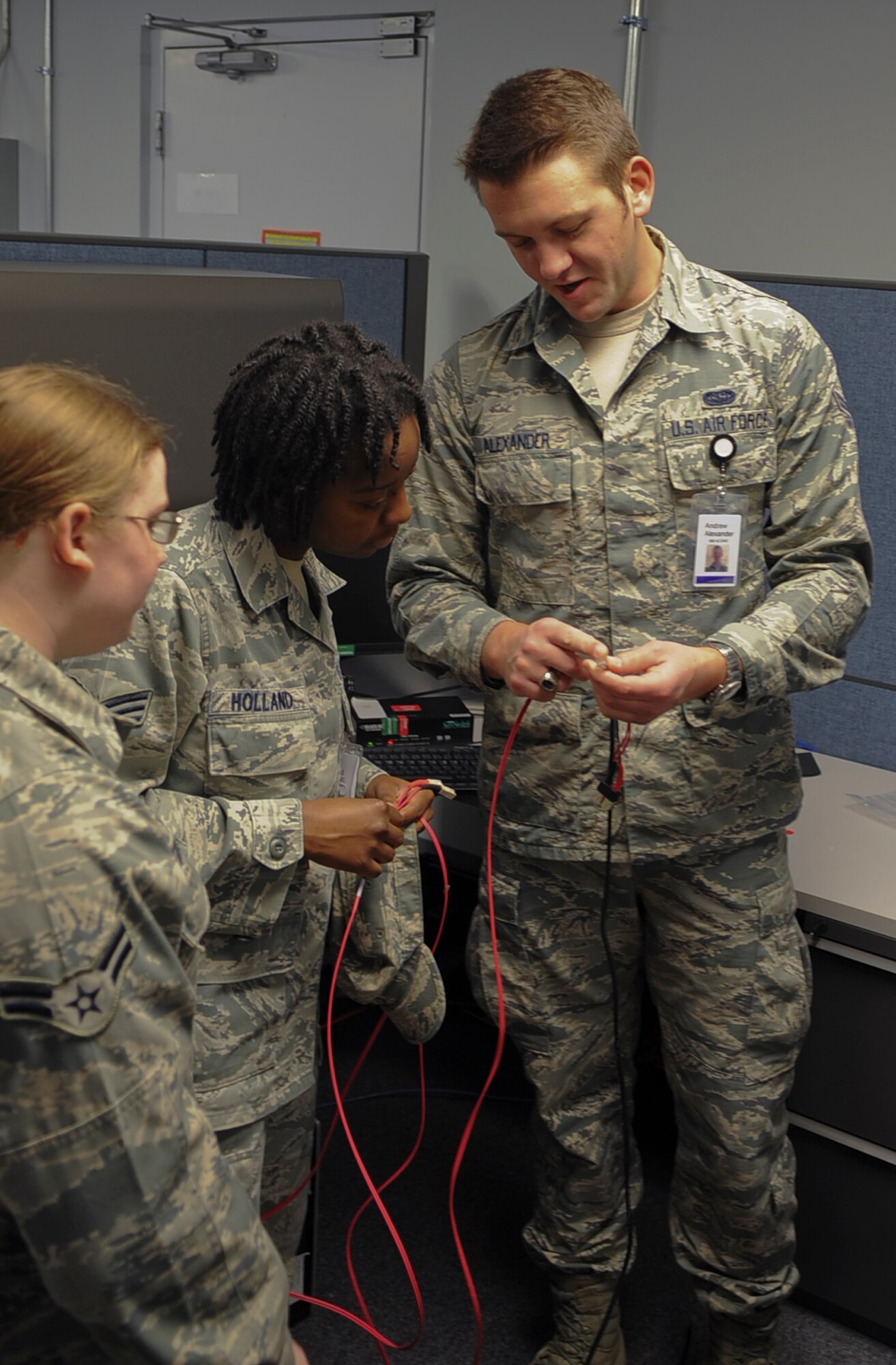 Airman 1st Class Andrew Alexander, 608th Air Communications Squadron client systems technician, explains the difference between a fiber optic connection and Category 5 network connection on Barksdale Air Force Base, La., Feb. 11. The 8th Air Force moved back on base, so all computer equipment and telephone systems had to be reconnected to the network for interconnectivity between Air Force Global Strike Command and the 2nd Bomb Wing. (U.S. Air Force photo/Staff Sgt. Jason McCasland)