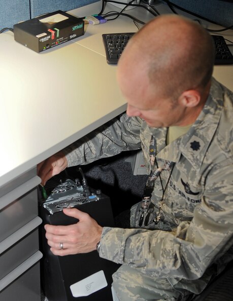 Lt. Col. Aaron Ullman, 8th Air Force air, space and logistics operations deputy director, re-installs his computer after moving to a temporary location on Barksdale Air Force Base, La., Feb. 11. The 8th AF moved back to the base to begin building a more responsive war fighting team with Air Force Global Strike Command and Barksdale's host units. (U.S. Air Force photo/Staff Sgt. Jason McCasland)