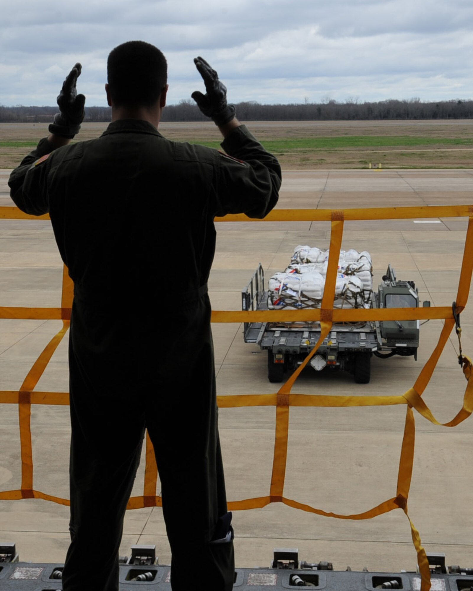 Senior Airman Juan Upegui, 2nd Air Refueling Squadron mission boom operator, spots a next generation small loader containing rice on Barksdale Air Force Base, La., Feb. 13. The Children's Lifeline Foundation donated 42,000 pounds of rice to Port au Prince, Haiti, where it will feed 8,000 children a day. The 2 ARS is assigned to Joint Base McGuire-Dix-Lakehurst, N.J. (U.S. Air Force photo/Senior Airman Sean Martin)