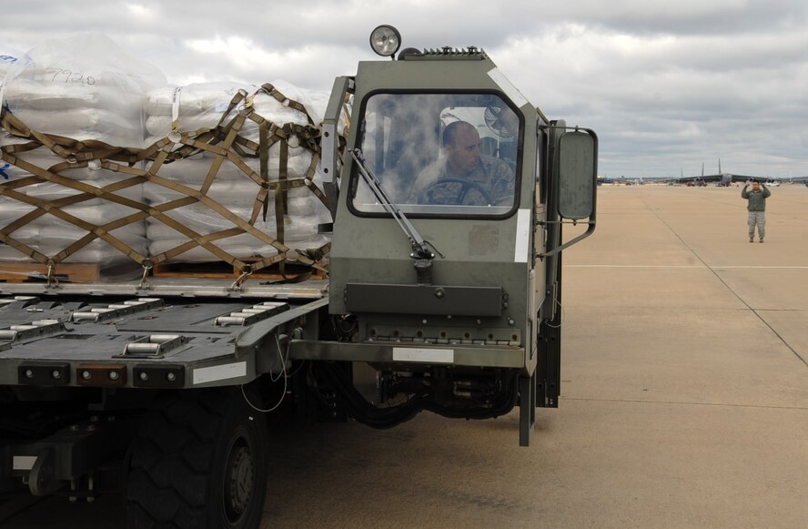 Tech. Sgt. Robert Charron is spotted by Staff Sgt. Bruce Toney, both from the 2nd Logistics Readiness Squadron air terminal operations, on Barksdale Air Force Base, La., Feb. 13. Pallets of rice were donated by the Children's Lifeline Foundation in support of the Denton Movement. The movement involved transporting 42,000 pounds of rice to Port au Prince, Haiti. (U.S. Air Force photo/Senior Airman Sean Martin)