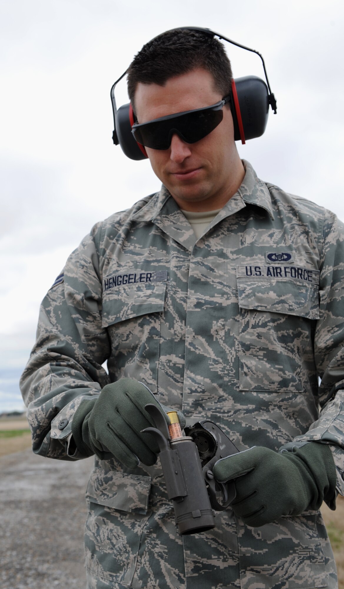 Airman 1st Class Andrew Henggeler, 2nd Operations Support Squadron airfield management, inserts a 12-gauge bullet into a pyrotechnics pistol on Barksdale Air Force Base, La., Feb. 13. The 12-gauge pistol launches a projectile that creates a small explosion near its desired target causing minimal collateral damage. The pistol is a non-lethal option for airfield managers to use when scaring birds away from the flightline. (U.S. Air Force photo/Airman 1st Class Benjamin Gonsier)

