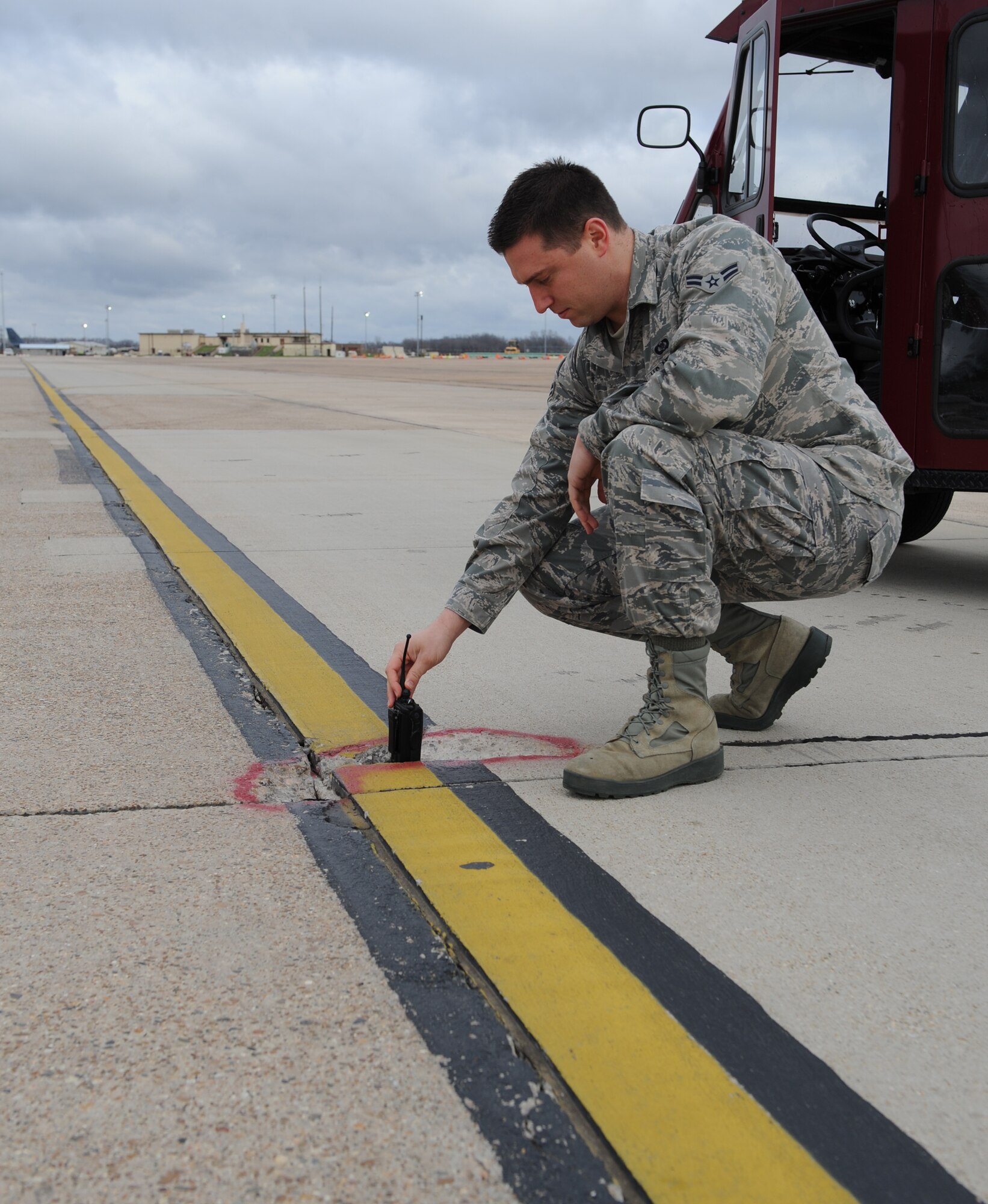 Airman 1st Class Andrew Henggeler, 2nd Operations Support Squadron airfield management, checks the depth of a hole in the pavement on the flightline at Barksdale Air Force Base, La., Feb. 13. Airfield management ensures safe operations of aircraft, personnel and vehicles on the airfield. (U.S. Air Force photo/Airman 1st Class Benjamin Gonsier)

