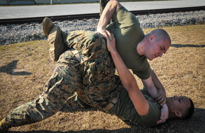 U.S. Marine Corps Sgt. Sean O’Donnell (top) and Lance Cpl. Jael Torres, Naval Consolidated Brig Charleston  corrections specialists, grapple during Marine Corps Martial Arts Program training Feb. 7, 2013, at Joint Base Charleston – Weapons Station, S.C. MCMAP is a hand-to-hand, close quarter combat and weapons training program designed to educate, improve technique and boost morale throughout the Corps.  Marines stationed at the NCBC participate in MCMAP four times a week. (U. S. Air Force photo/Airman 1st Class Jared Trimarchi) 
