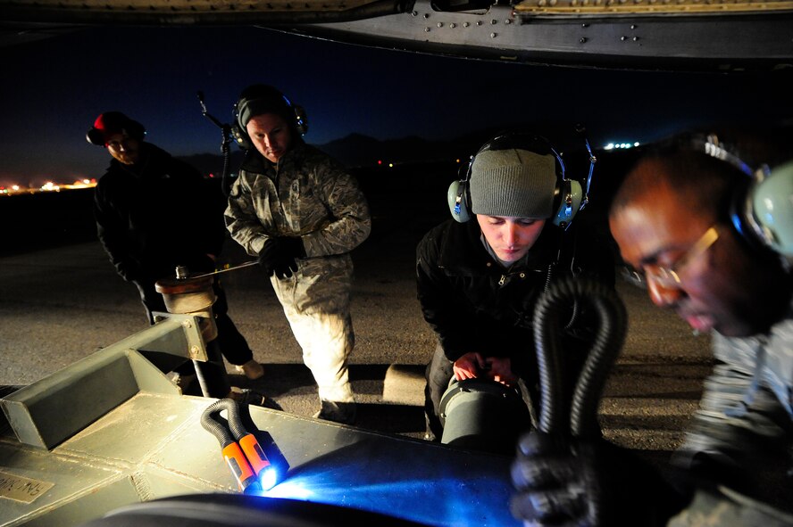 U.S. airmen and civilian contractors attach a tow bar to the nose landing gear of a C-5M Super Galaxy aircraft Jan. 26, 2013, at Camp Marmal, Afghanistan. The aircraft, assigned to the 436th Airlift Wing at Dover Air Force Base, Del., was forward deployed to assist with the scheduled rotation of two U.S. Army aviation task forces. (U.S. Air Force photo by Tech Sgt. Parker Gyokeres/Released)