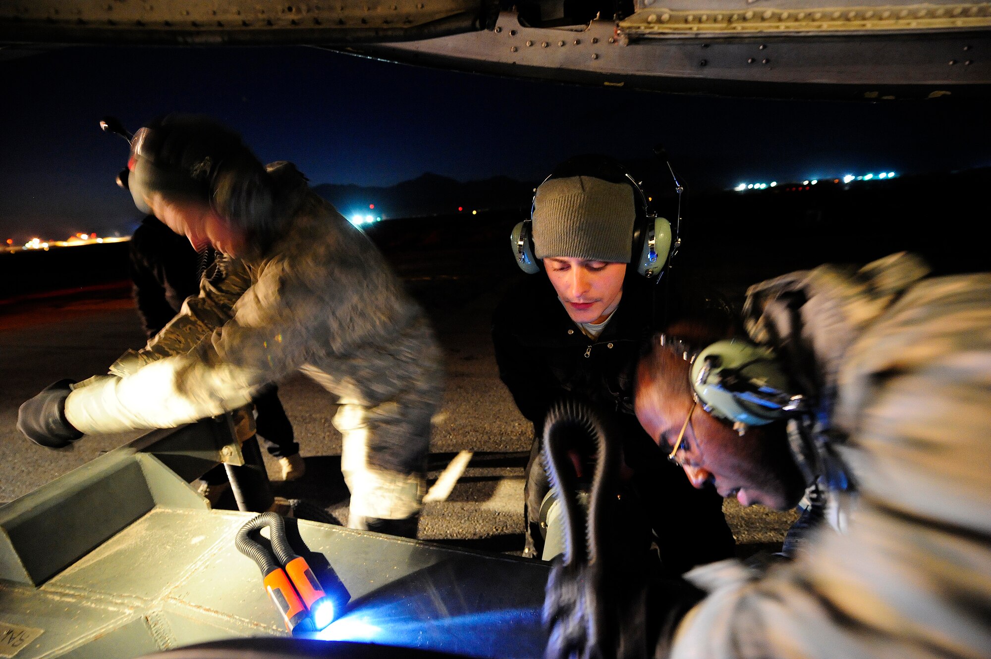 U.S. airmen and civilian contractors attach a tow bar to the nose landing gear of a C-5M Super Galaxy aircraft Jan. 26, 2013, at Camp Marmal, Afghanistan. The aircraft, assigned to the 436th Airlift Wing at Dover Air Force Base, Del., was forward deployed to assist with the scheduled rotation of two U.S. Army aviation task forces. (U.S. Air Force photo by Tech Sgt. Parker Gyokeres/Released)
