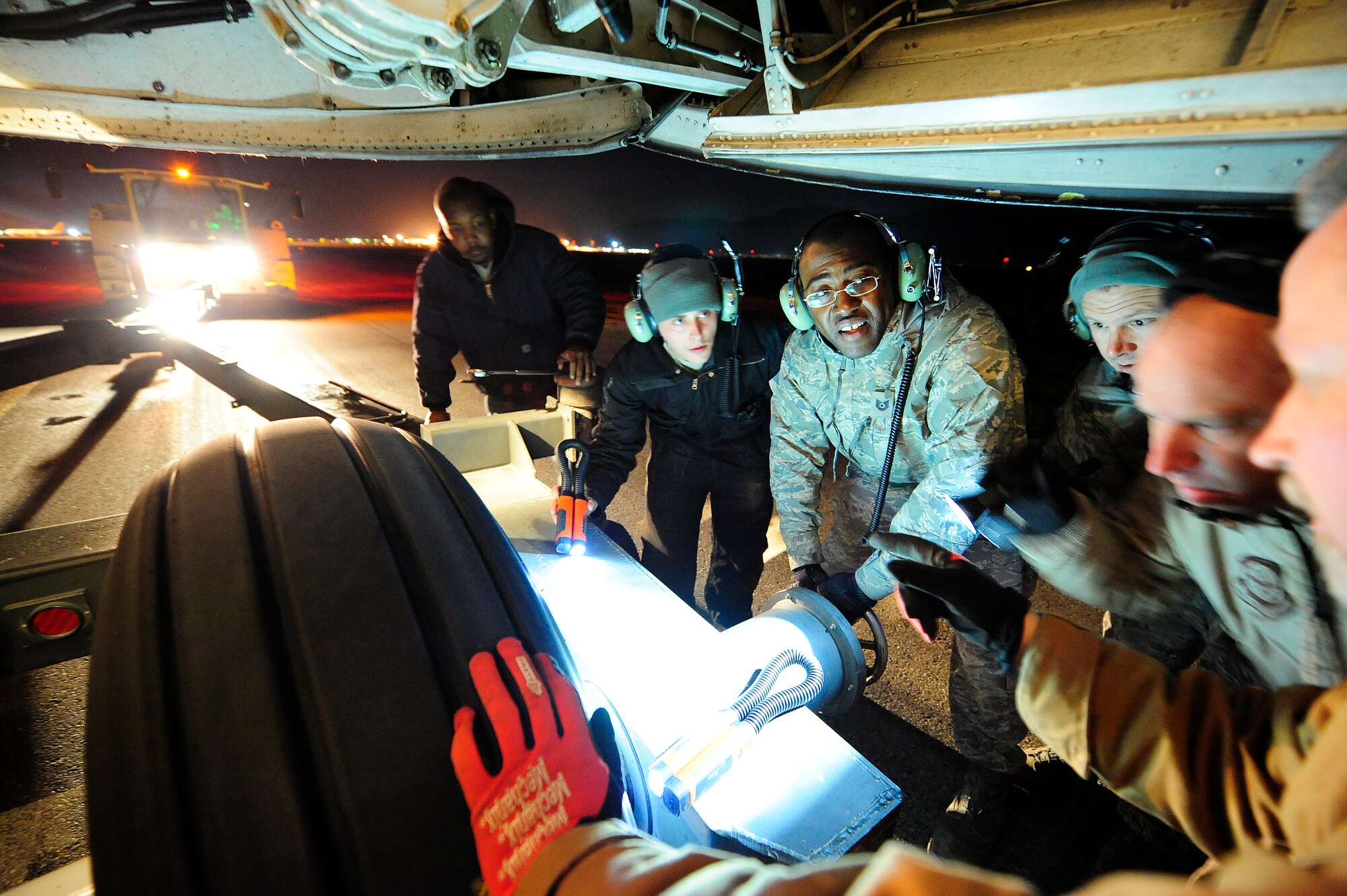 U.S. airmen and civilian contractors attach a tow bar to the nose landing gear of a C-5M Super Galaxy aircraft Jan. 26, 2013, at Camp Marmal, Afghanistan. The aircraft, assigned to the 436th Airlift Wing at Dover Air Force Base, Del., was forward deployed to assist with the scheduled rotation of two U.S. Army aviation task forces. (U.S. Air Force photo by Tech Sgt. Parker Gyokeres/Released)