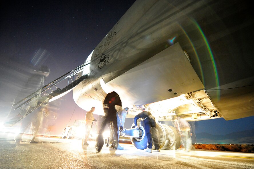 U.S. airmen and civilian contractors attach a tow bar to the nose landing gear of a C-5M Super Galaxy aircraft Jan. 26, 2013, at Camp Marmal, Afghanistan. The aircraft, assigned to the 436th Airlift Wing at Dover Air Force Base, Del., was forward deployed to assist with the scheduled rotation of two U.S. Army aviation task forces. (U.S. Air Force photo by Tech Sgt. Parker Gyokeres/Released)