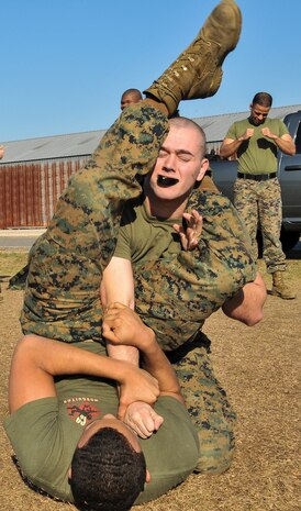 U.S. Marine Corps Lance Cpl. Brandon Everhart (top) and Lance Cpl. Jael Torres, Naval Consolidated Brig Charleston corrections specialists, wrestle during Marine Corps Martial Arts Program training Feb. 7, 2013, at Joint Base Charleston – Weapons Station, S.C. MCMAP is a hand-to-hand, close quarter combat and weapons training program designed to educate, improve technique and boost morale throughout the Corps.  Marines stationed at the NCBC participate in MCMAP four times a week. (U. S. Air Force photo/Airman 1st Class Jared Trimarchi) 