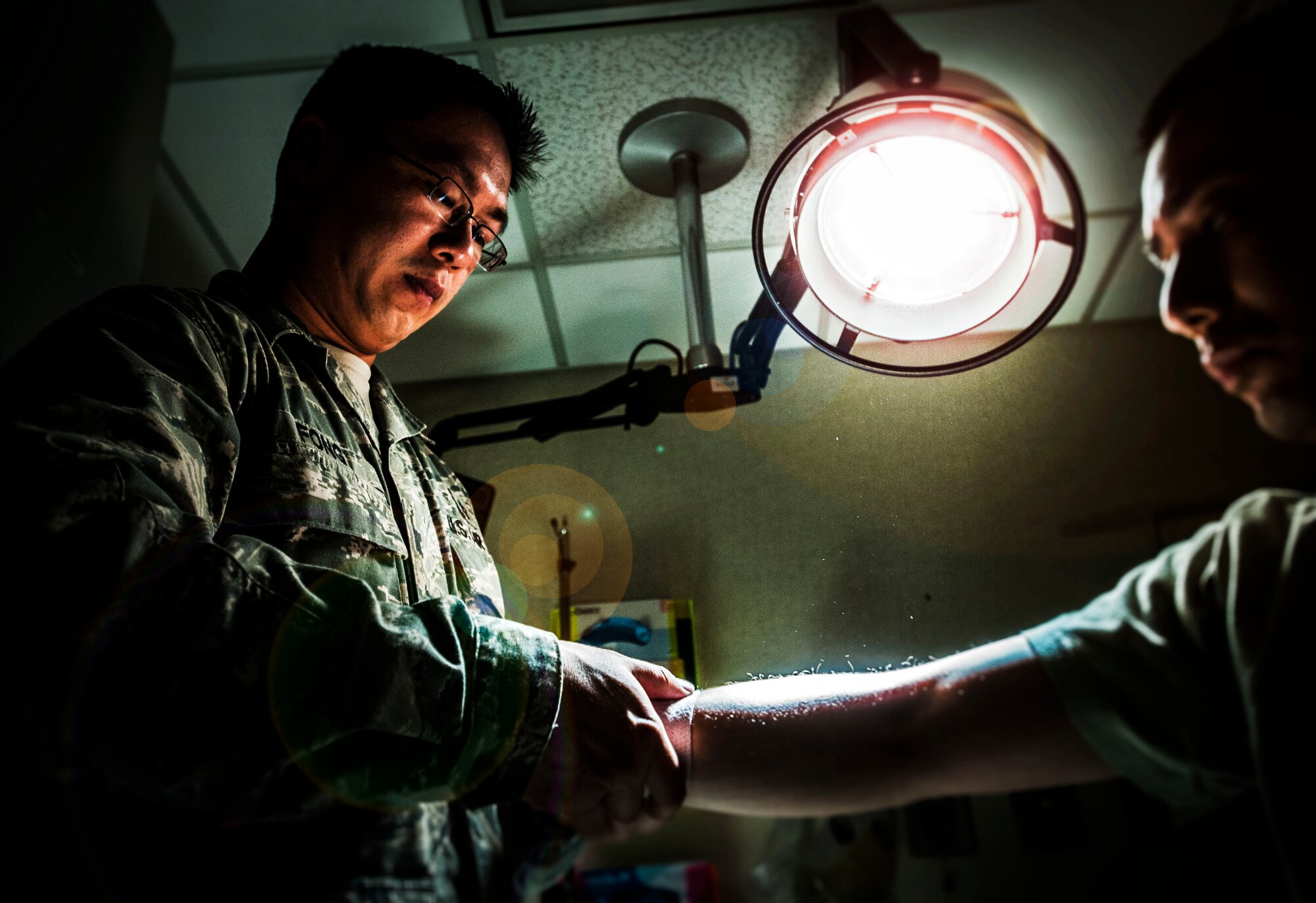 Tech Sgt. Chun Chung Fong, 628th Medical Group Primary Care Flight, flight chief, demonstrates a routine exam on an Airman at Joint Base Charleston – Air Base, Feb. 12, 2013. The IDMTs’ mission is to save lives while accomplishing various jobs. They provide and manage patient care while at home station. (U.S. Air Force photo / Airman 1st Class Tom Brading)