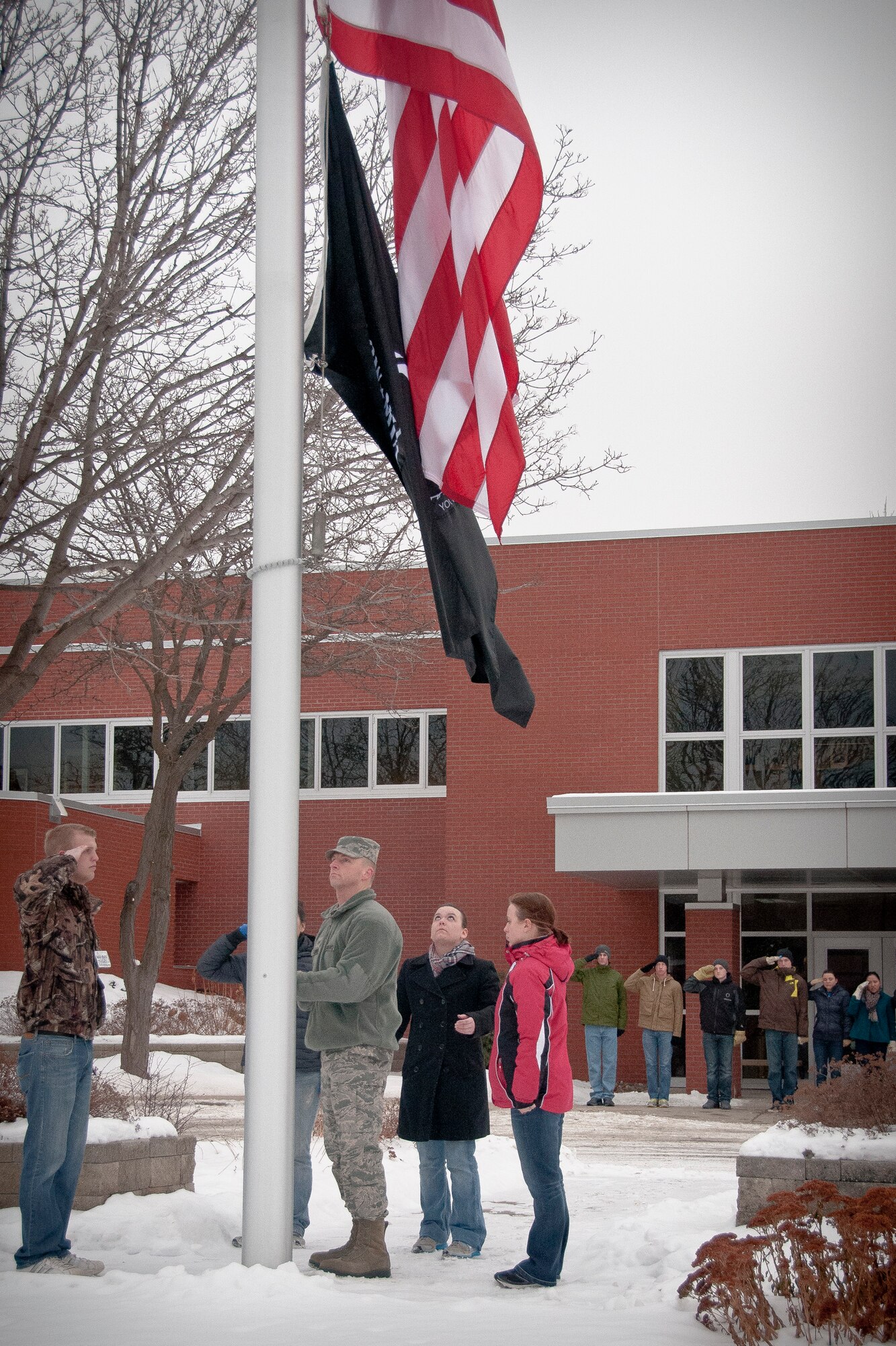 Luke Miller, Sarah Pearson, Jennifer Kasper, and Morgan MacFarlane, members of the 934th Airlift Wing Development Training Flight, excute present arms while Tech. Sgt. Ricky Zenner, Noncommissioned Officer in Charge of the 934 DTF, lowers flag during retreat.  The 934 DTF was tasked to perform the reveille and retreat ceremonies during the February Unit Training Assembly at the Minneapolis-St. Paul Air Reserve Station, Minn.  (U.S. Air Force photo/Staff Sgt. Samantha Wagner)