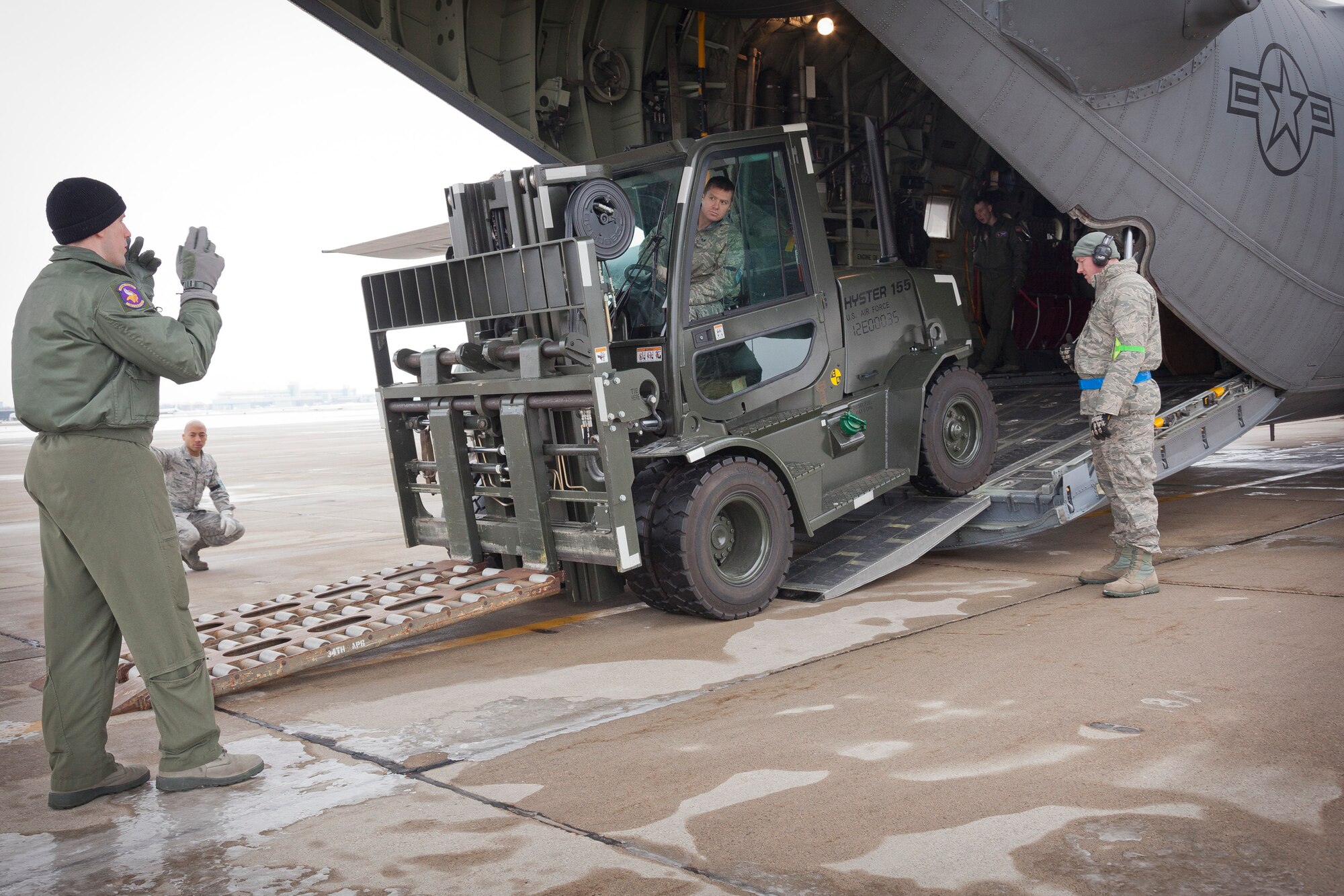 Senior Airman Vernon McCray, 27th Aerial Port Squadron, looks to Staff Sgt. Dylan Strom, 96 Airlift Squadron loadmaster, to help guide him as he loads a forklift during an exercise.  The 27 APS conducts the training exercise in preparation for the upcoming Operational Readiness Exercise/Inspection at the Minneapolis-St. Paul Air Reserve Station, Minn.  (U.S. Air Force photo/Shannon McKay)