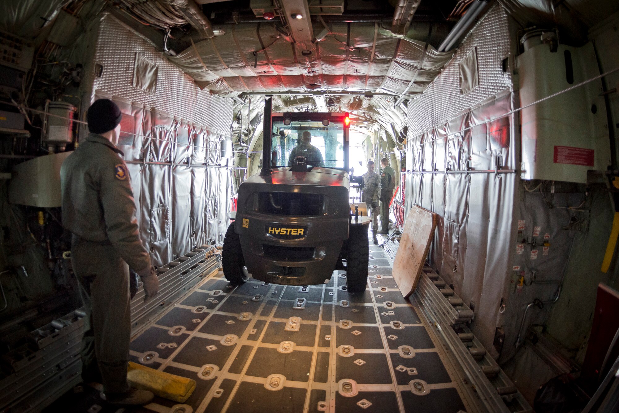 Staff Sgt. Justin Gort, 96th Airlift Squadron loadmaster, watches the distance for Staff Sgt. John Akan, 27th Aerial Port Squadron, as he loads a forklift onto a C-130.  The 27 APS conducts the training exercise in preparation for the upcoming Operational Readiness Exercise/Inspection at the Minneapolis-St. Paul Air Reserve Station, Minn.  (U.S. Air Force photo/Shannon McKay)