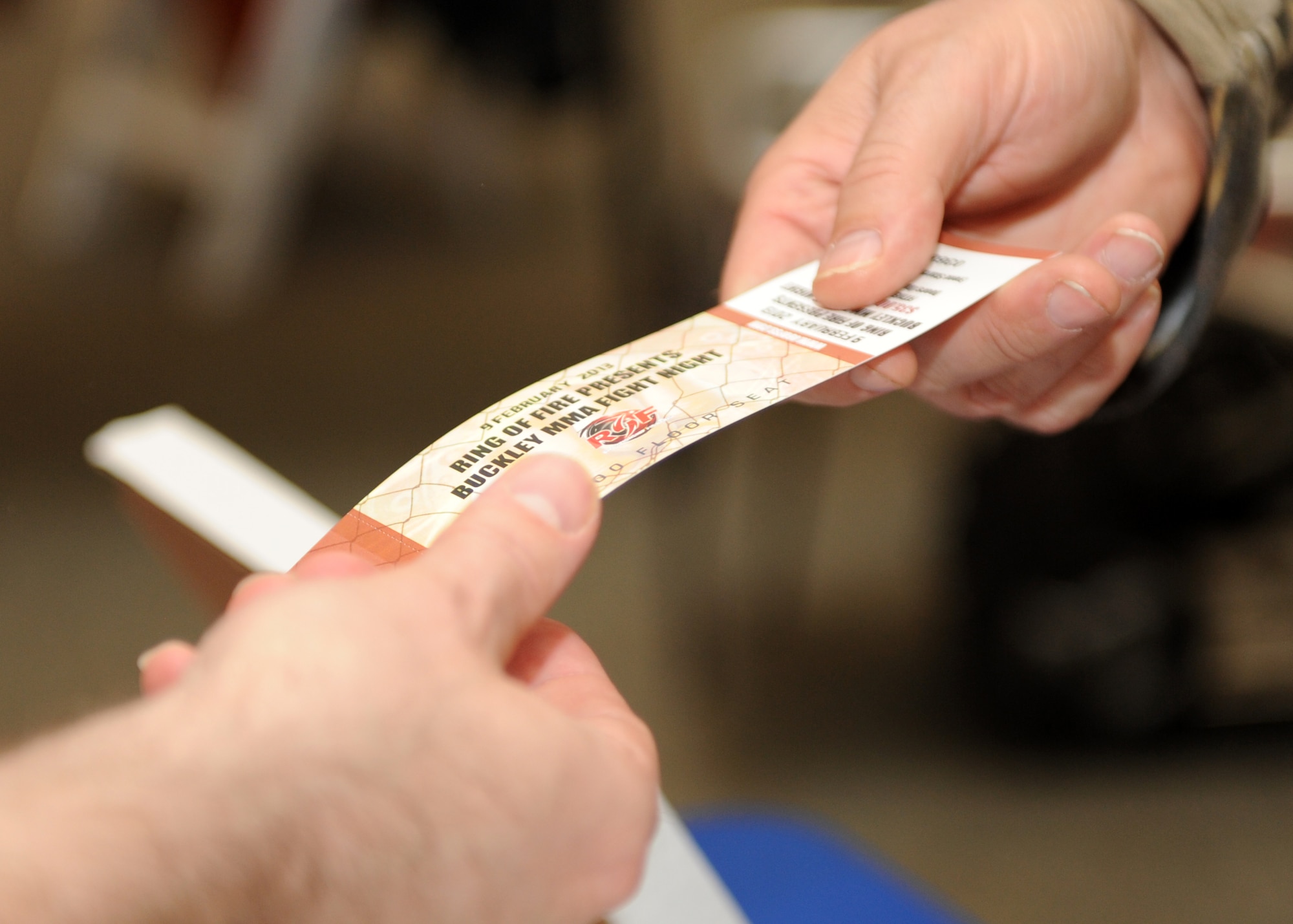 A volunteer takes a ticket for the Buckley MMA Fight Night Feb. 9, 2013, at the Buckley Air Force Base Fitness Center. The first sanctioned fight held at a military base was aired on pay-per-view and benefited the Wounded Warrior Project. (U.S. Air Force photo by Senior Airman Marcy Glass/Released)