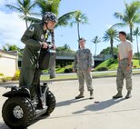 Caleb Jensen, Pilot For a Day participant, rides a segway Senior Airmen Wesley McCrane and Vincent Irr, 647th Civil Engineer Squadron munitions apprentices look on, as part of the Pilot for a Day program at Joint Base Pearl Harbor-Hickam, Hawaii, Feb. 08, 2013. After having successfully completed treatment for aplastic anemia, a condition which causes the body to stop producing new blood cells, Caleb was joined on base by his mother, father, brother and three sisters to participate in the Pilot For a Day program. (U.S. Air Force photo/Tech. Sgt. Jerome S. Tayborn)