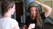 Brooklin Jensen helps her mother Melissa Jensen try on a helmet as she poses for pictures at the 647th Civil Engineer Squadron, Explosive Ordnance Disposal work center shortly after touring the facility with her son Caleb Jensen, Pilot For a Day selectee and aplastic anemia survivor, as part of the Pilot for a Day program at Joint Base Pearl Harbor-Hickam, Hawaii, Feb. 8, 2013. After having successfully completed treatment for aplastic anemia, a condition which causes the body to stop producing new blood cells, Caleb was joined on base by his mother, father, brother and three sisters to participate in the Pilot For a Day program. (U.S. Air Force photo/Tech. Sgt. Jerome S. Tayborn)