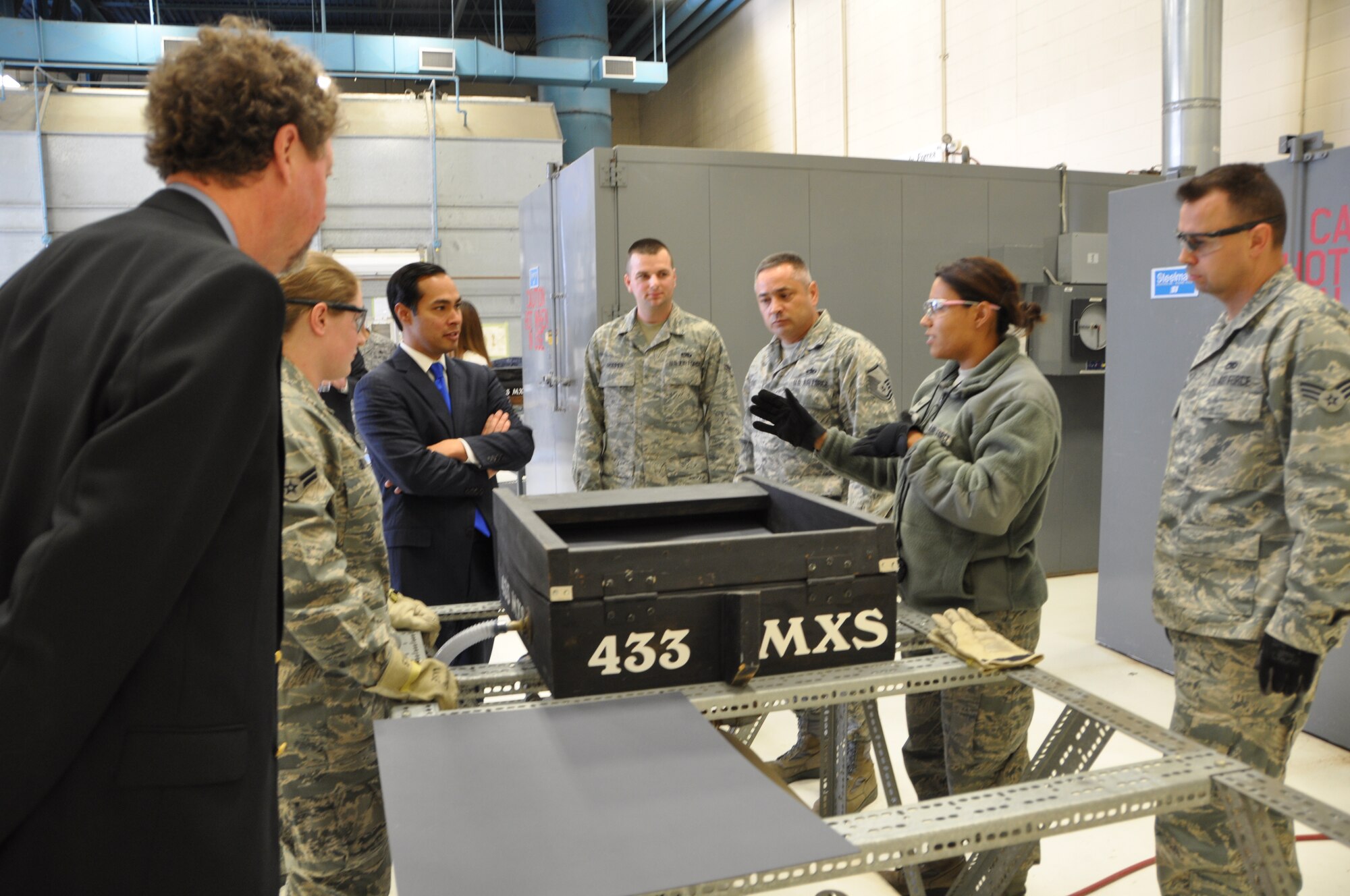 Senior Airman Stephanie Rymers, center right, structural aircraft technician at the 433rd Airlift Wing's Corrosion Shop, explains to San Antonio Mayor Julian Castro the window-reveal mold machine prior to the demonstration of how window-reveal mold components are manufactured for the wing's C-5A Galaxy fleet. The mayor visited the wing on Feb. 12, 2013 to learn about the "Alamo Wing's" missions and its role within the Air Force Reserve. (U.S. Air Force photo by Elsa Martinez)