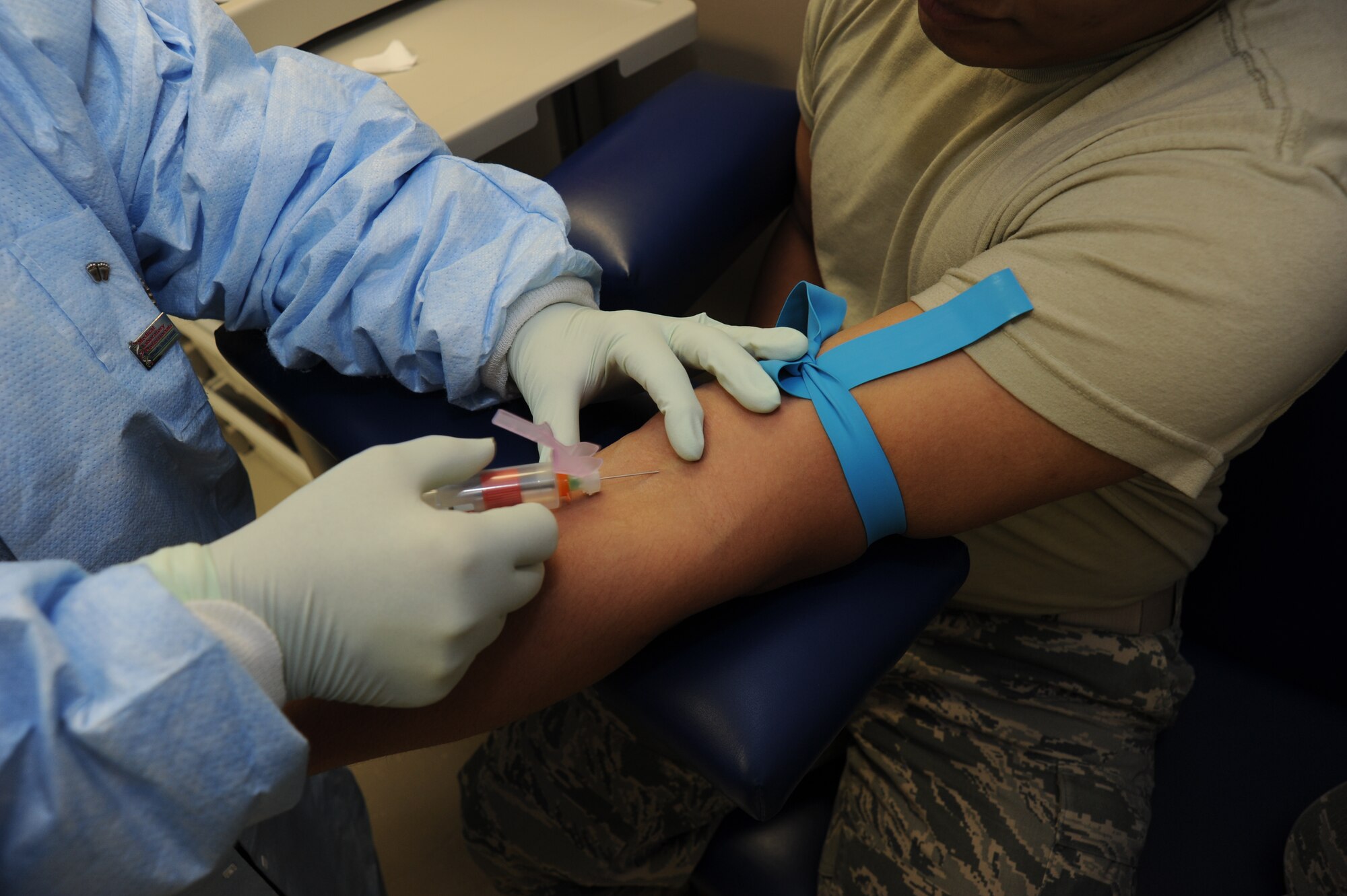 Lana Jones, 92nd Medical Support Squadron laboratory technician, draws blood from Airman 1st Class Tony Tran, 92nd communications squadron knowledge operator, at Fairchild Air Force Base Wash., Feb. 8, 2013. The lab techs either push the blood samples through an analyzer to get quick results, or they observe the blood sample through the microscope for a more detailed analysis. (U.S. Air Force photo by Senior Airman Jordan Pollock) 