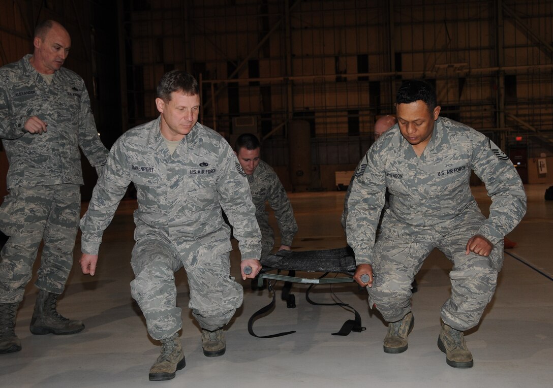 Chief Master Sgt. Leon Alexander (left), 908th Maintenance Group, Maxwell Air Force Base, Ala., teaches 512th Airlift Wing reservists how to properly lift a litter when providing first responder assistance during operational readiness exercise training Feb. 10, 2013, at Dover AFB, Del. Litter carrying techniques will be inspected during the ORE at Dover AFB, Del., in March. (U.S. Air Force photo/Senior Airman Joe Yanik)