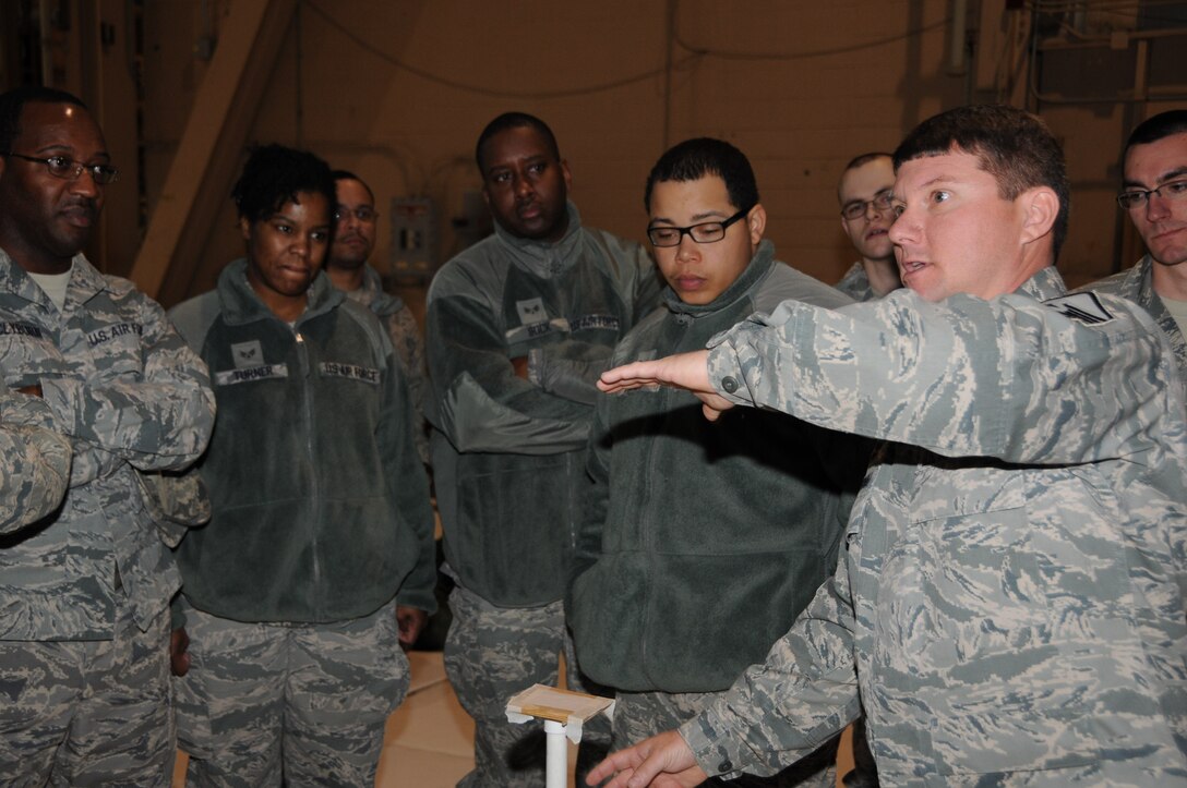 Master Sgt. William Lyndall (right), 908th Maintenance Group, Maxwell Air Force Base, Ala., explains to 512th Airlift Wing reservists how to properly set up chemical agent detection stations using M8 Paper during operational readiness exercise training Feb. 10, 2013, at Dover Air Force Base, Del. Lyndall advised the reservists on how M8 Paper should be placed where it can be easily seen on flat horizontal surfaces that are likely to become contaminated during a chemical attack. (U.S. Air Force photo/Senior Airman Joe Yanik)