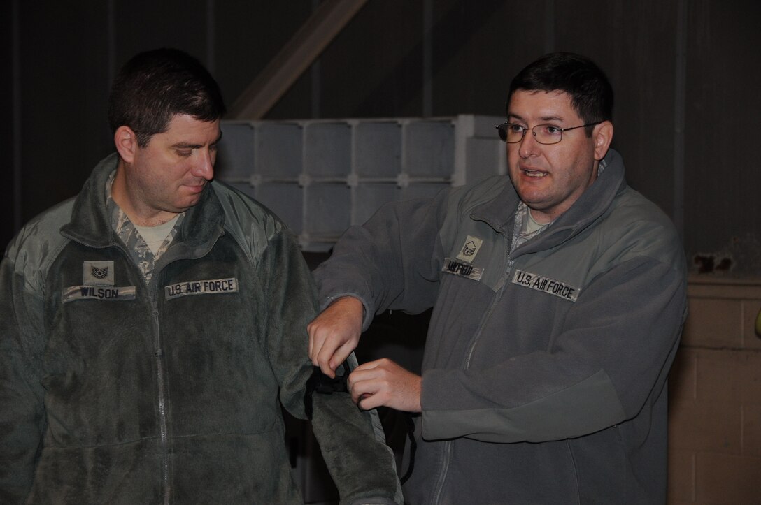 Master Sgt. William Mayfield (right), 908th Maintenance Group, Maxwell Air Force Base, Ala., demonstrates how to secure a tourniquet on Tech. Sgt. Jeffrey Wilson, 46th Aerial Port Squadron, as part of self-aid buddy care training Feb. 10, 2013, at Dover AFB, Del. Mayfield reviewed other methods of SABC using the Airman’s Manual. (U.S. Air Force photo/Senior Airman Joe Yanik)