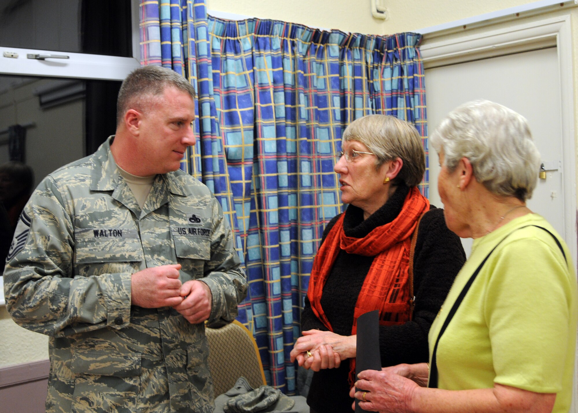 Senior Master Sgt. Randy Walton, 100th Maintenance Squadron fabrication flight chief from, speaks to two members of the Women’s Institute during a meeting Feb. 12, 2013 in Barton Mills, England. Walton a Conrad, Iowa, native, spoke about the unique situation of being an Airmen married to another service member and raising a child overseas. (U.S. Air Force photo by Airman 1st Class Kelsey Waters/Released)
