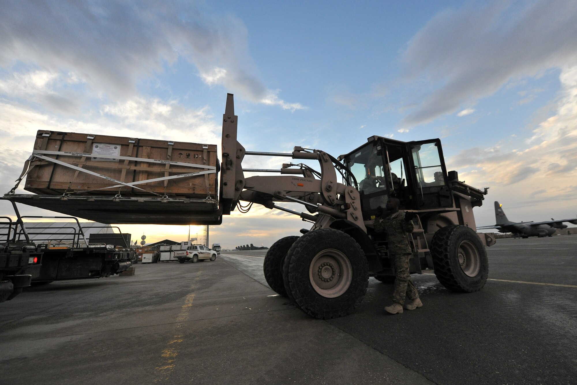 Staff Sgt. Gary Williams, 455th Expeditionary Aerial Port Squadron, Detachment 3 Aerial Port specialist, guides a forklift across the contingency cargo staging yard at Camp Marmal, Afghanistan, Jan 30, 2013. Williams is deployed from the 60th Aerial Port Squadron, Travis Air Force Base, Calif., supporting the International Security Assistance Force Regional Command-North transportation mission. (U.S. Air Force photo/Senior Airman Chris Willis)