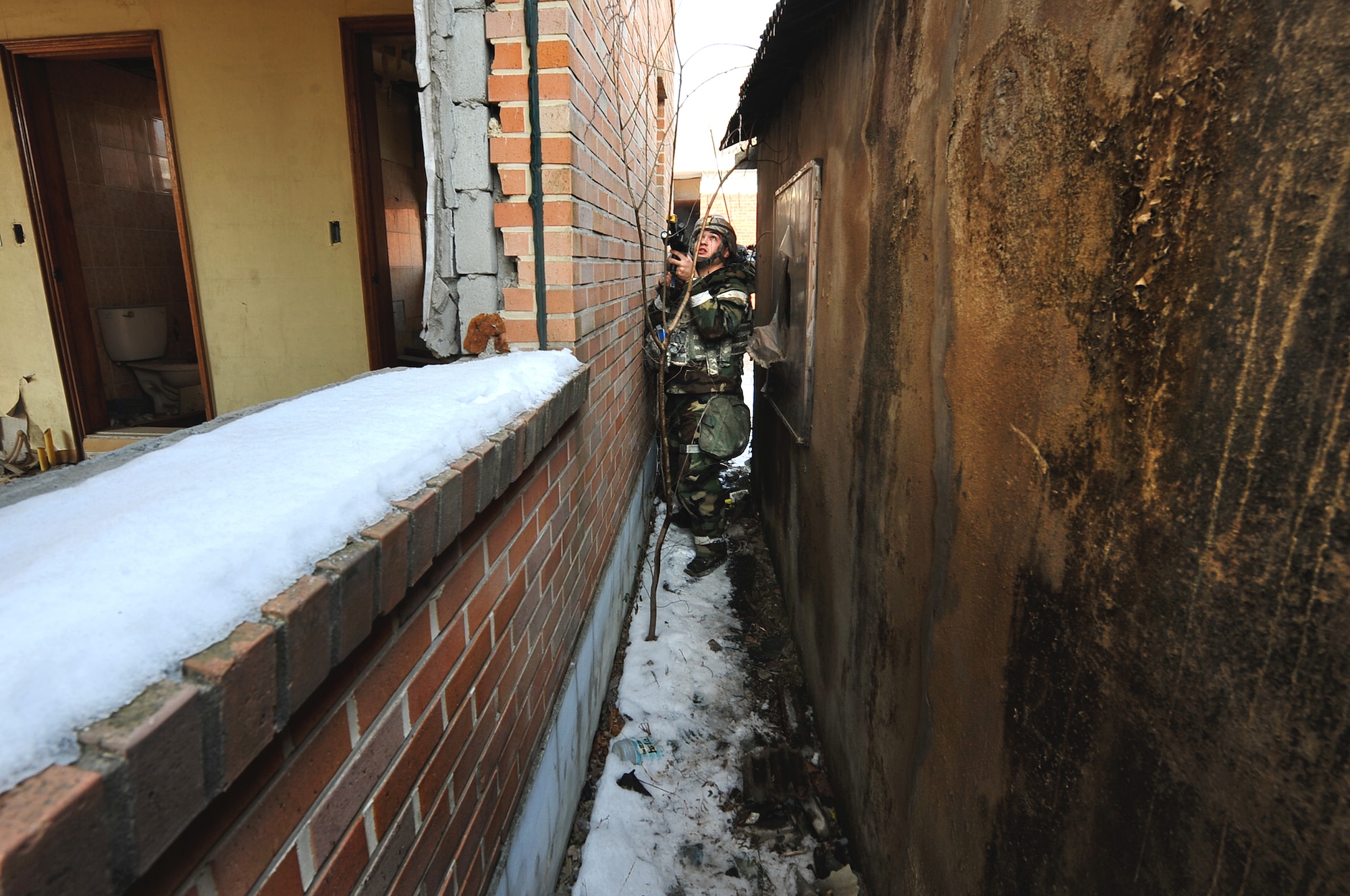 Senior Airman Christopher Hahn, 51st Security Forces member, checks his surroundings for enemy threats during a counter surveillance scenario for an operation readiness exercise, Beverly Bulldog 13-02 at Osan Air Base, Republic of Korea, Feb. 12, 2013. Counter surveillance scenarios are conducted to help train security forces Airmen to deny opposing forces entry to the base. (U.S. Air Force photo/Staff Sgt. Sara Csurilla)