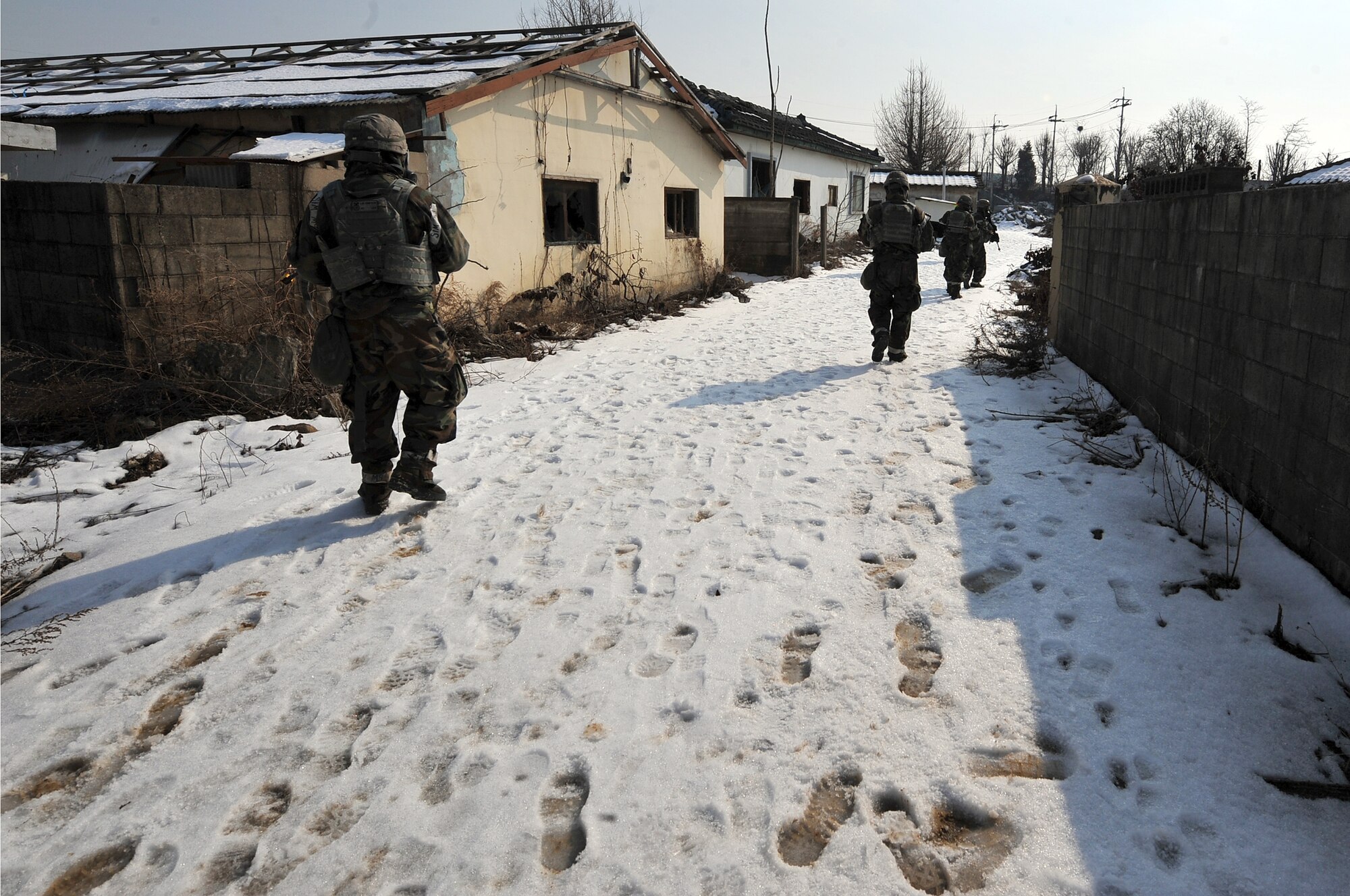 Airmen from the 51st Security Forces Squadron clear a village of mock enemy threats during a counter surveillance scenario for operation readiness exercise Beverly Bulldog 13-02 at Osan Air Base, Republic of Korea, Feb. 12, 2013. These exercises tests Osan Airmen’s abilities during a heightened state of readiness while providing combat ready forces for close air support, air strike control, counter air, interdiction, theater airlift, and communications in the defense of the Republic of Korea. (U.S. Air Force photo/Staff Sgt. Sara Csurilla)