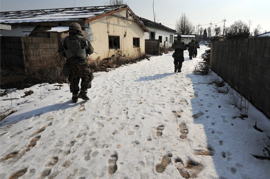 Airmen from the 51st Security Forces Squadron clear a village of mock enemy threats during a counter surveillance scenario for operation readiness exercise Beverly Bulldog 13-02 at Osan Air Base, Republic of Korea, Feb. 12, 2013. These exercises tests Osan Airmen’s abilities during a heightened state of readiness while providing combat ready forces for close air support, air strike control, counter air, interdiction, theater airlift, and communications in the defense of the Republic of Korea. (U.S. Air Force photo/Staff Sgt. Sara Csurilla)