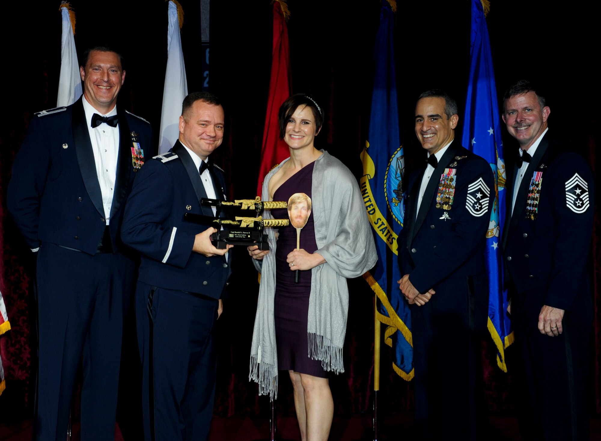 Susan Harvey, spouse of U.S. Air Force Capt. Randall Harvey, 353rd Special Operations Group, accepts an award on behalf of her husband from Col. Brad Sullivan, 353rd SOG commander, during the annual awards ceremony at the Rocker NCO Club on Kadena Air Base, Japan, Feb. 9, 2013. Harvey was recognized as Team Kadena's Company Grade Officer of the Year for 2012. (U.S. Air Force photo/Airman 1st Class Justin Veazie)