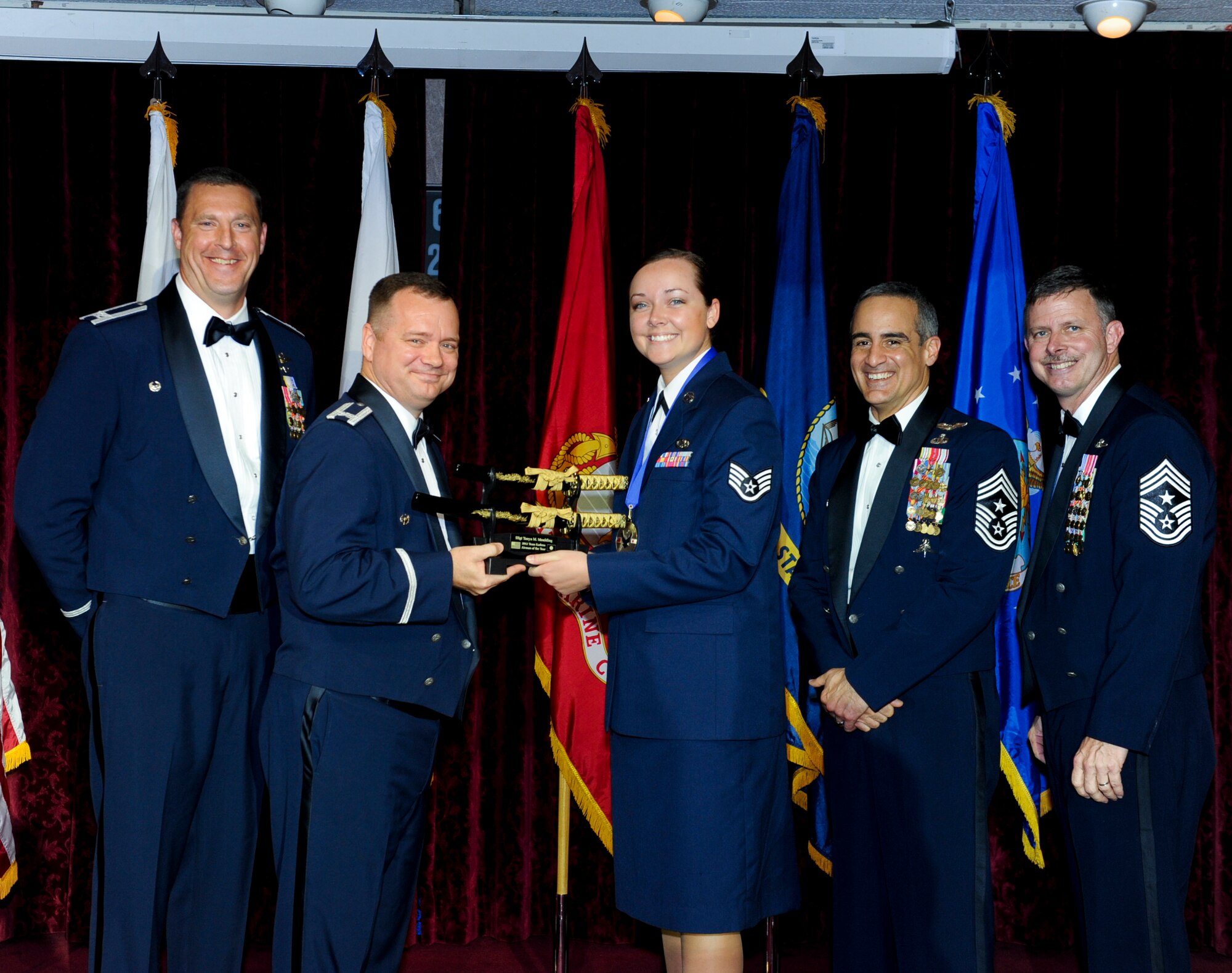 U.S. Air Force Staff Sgt. Tanya Moulding, 18th Component Maintenance Squadron, receives an award from Col. Brian McDaniel, 18th Wing vice commander, during the annual awards ceremony at the Rocker NCO Club on Kadena Air Base, Japan, Feb. 9, 2013. Moulding was recognized as Team Kadena's Airman of the Year for 2012. (U.S. Air Force photo/Airman 1st Class Justin Veazie)