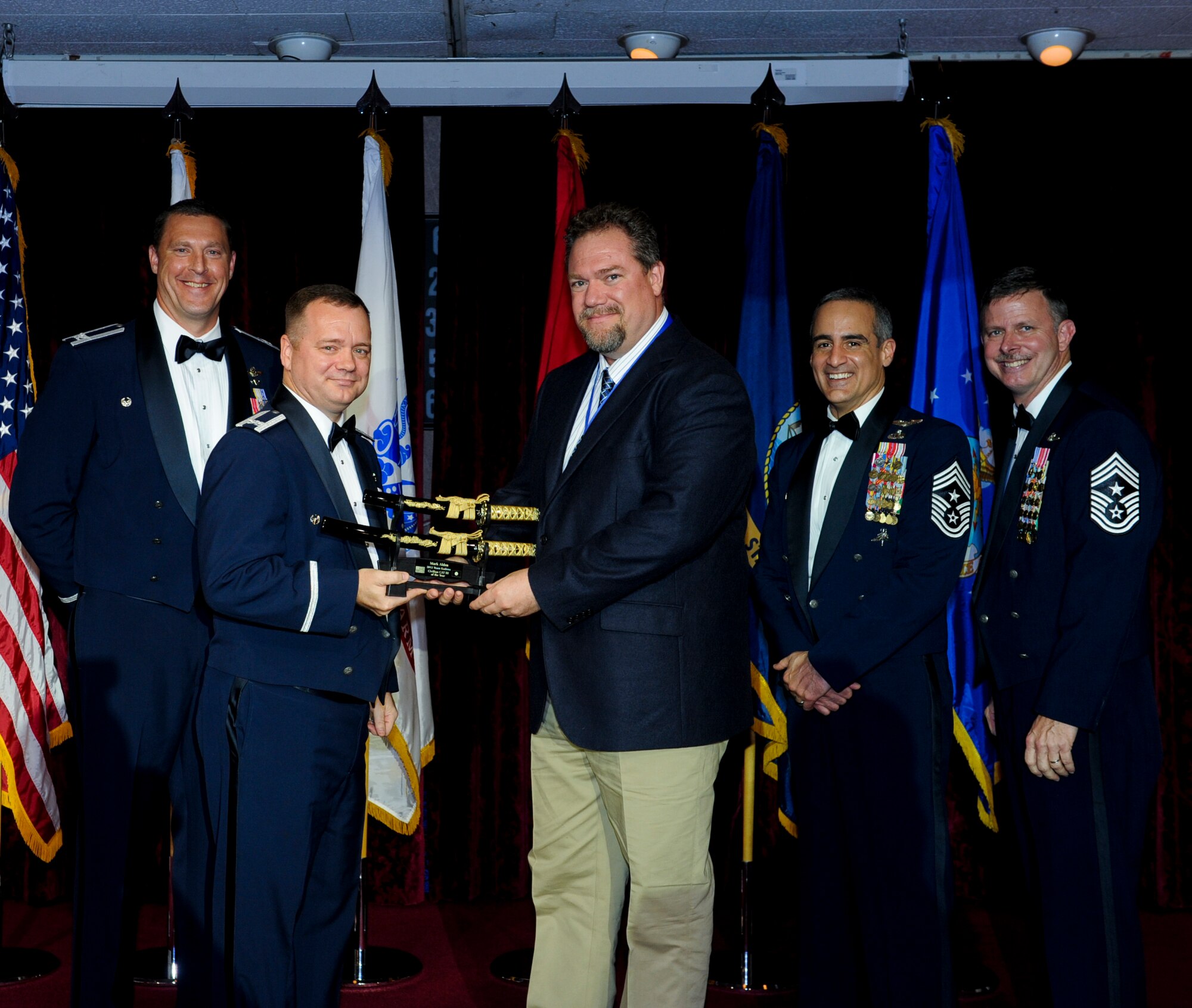 Mark Alden, 353rd Special Operations Group, receives an award from U.S. Air Force Col. Brad Sullivan, 353rd SOG commander, during the annual awards ceremony at the Rocker NCO Club on Kadena Air Base, Japan, Feb. 9, 2013. Alden was recognized as Team Kadena's Category III Civilian of the Year for 2012. (U.S. Air Force photo/Airman 1st Class Justin Veazie)