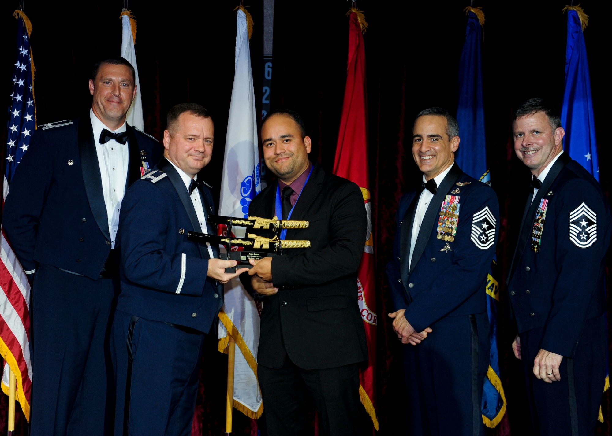 Adan Jaime, 18th Mission Support Group, receives an award from U.S. Air Force Col. Brian McDaniel, 18th Wing vice commander, during the annual awards ceremony at the Rocker NCO Club on Kadena Air Base, Japan, Feb. 9, 2013. Jaime was recognized as Team Kadena's Category II Civilian of the Year for 2012. (U.S. Air Force photo/Airman 1st Class Justin Veazie)