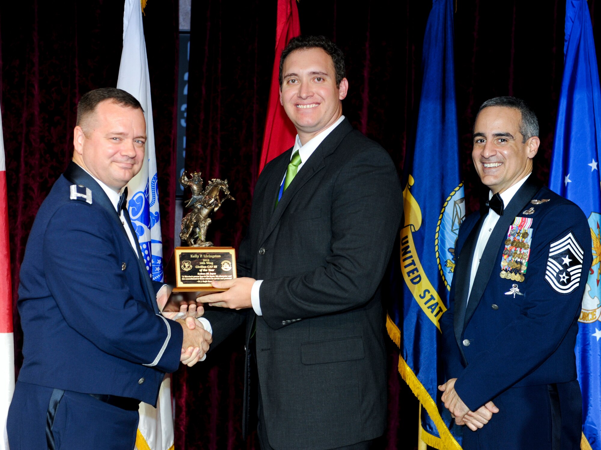 Kelly Livingston, 718th Civil Engineer Squadron, receives an award from U.S. Air Force Col. Brian McDaniel, 18th Wing vice commander, during the annual awards ceremony at the Rocker NCO Club on Kadena Air Base, Japan, Feb. 9, 2013. Livingston was recognized as the 18th Wing Category III Civilian of the Year for 2012. (U.S. Air Force photo/Airman 1st Class Justin Veazie)