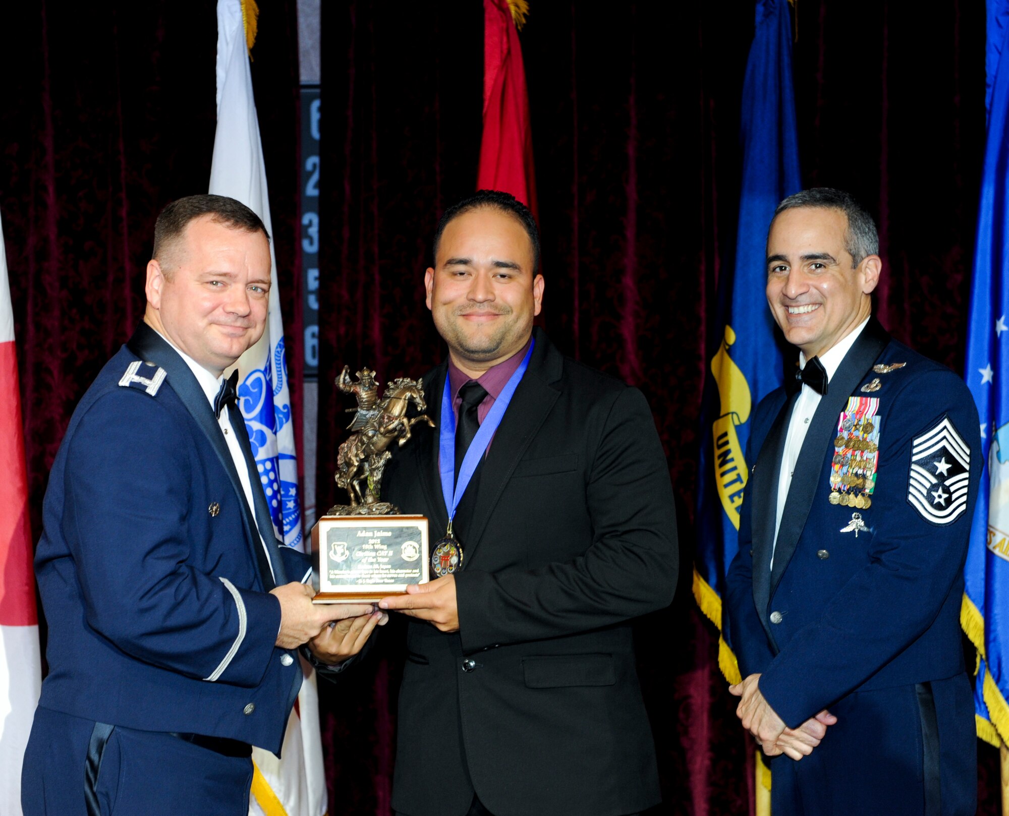 Adan Jaime, 18th Mission Support Group, receives an award from U.S. Air Force Col. Brian McDaniel, 18th Wing vice commander, during the annual awards ceremony at the Rocker NCO Club on Kadena Air Base, Japan, Feb. 9, 2013. Jaime was recognized as the 18th Wing Category II Civilian of the Year for 2012. (U.S. Air Force photo/Airman 1st Class Justin Veazie)